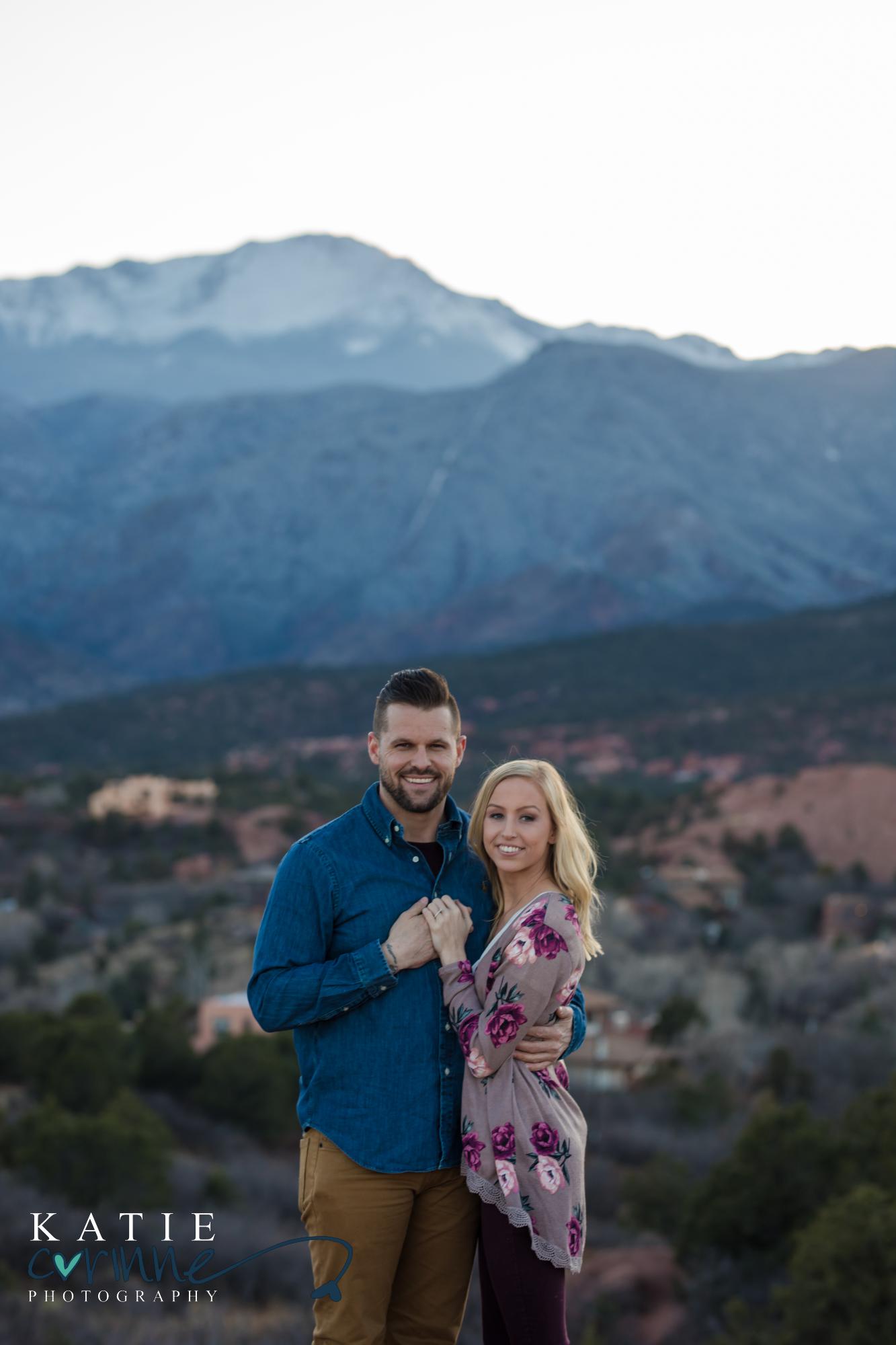 Couple celebrates engagement in front of mountains
