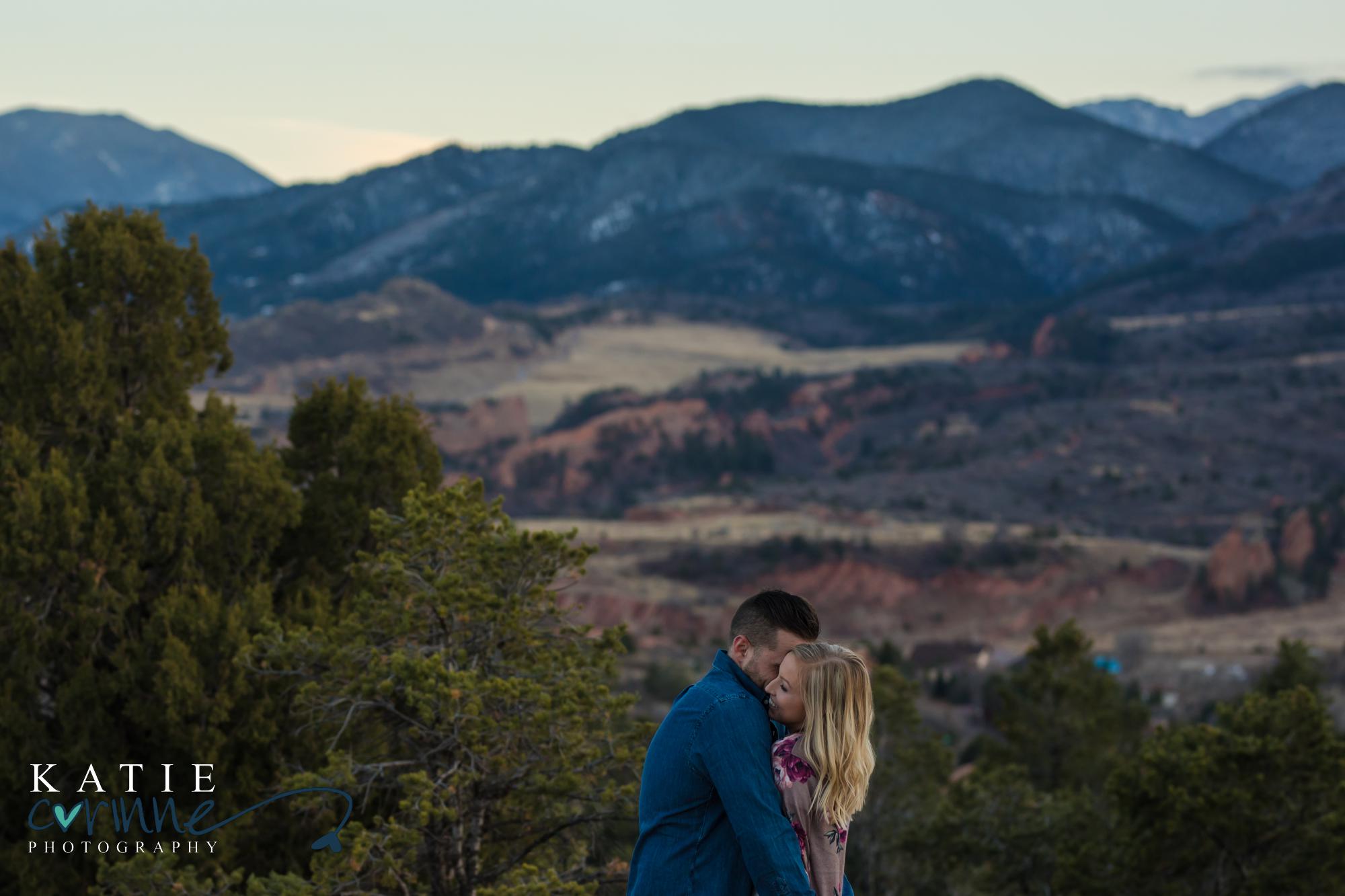 Colorado Springs couple embraces in front of Rocky Mountain landscape
