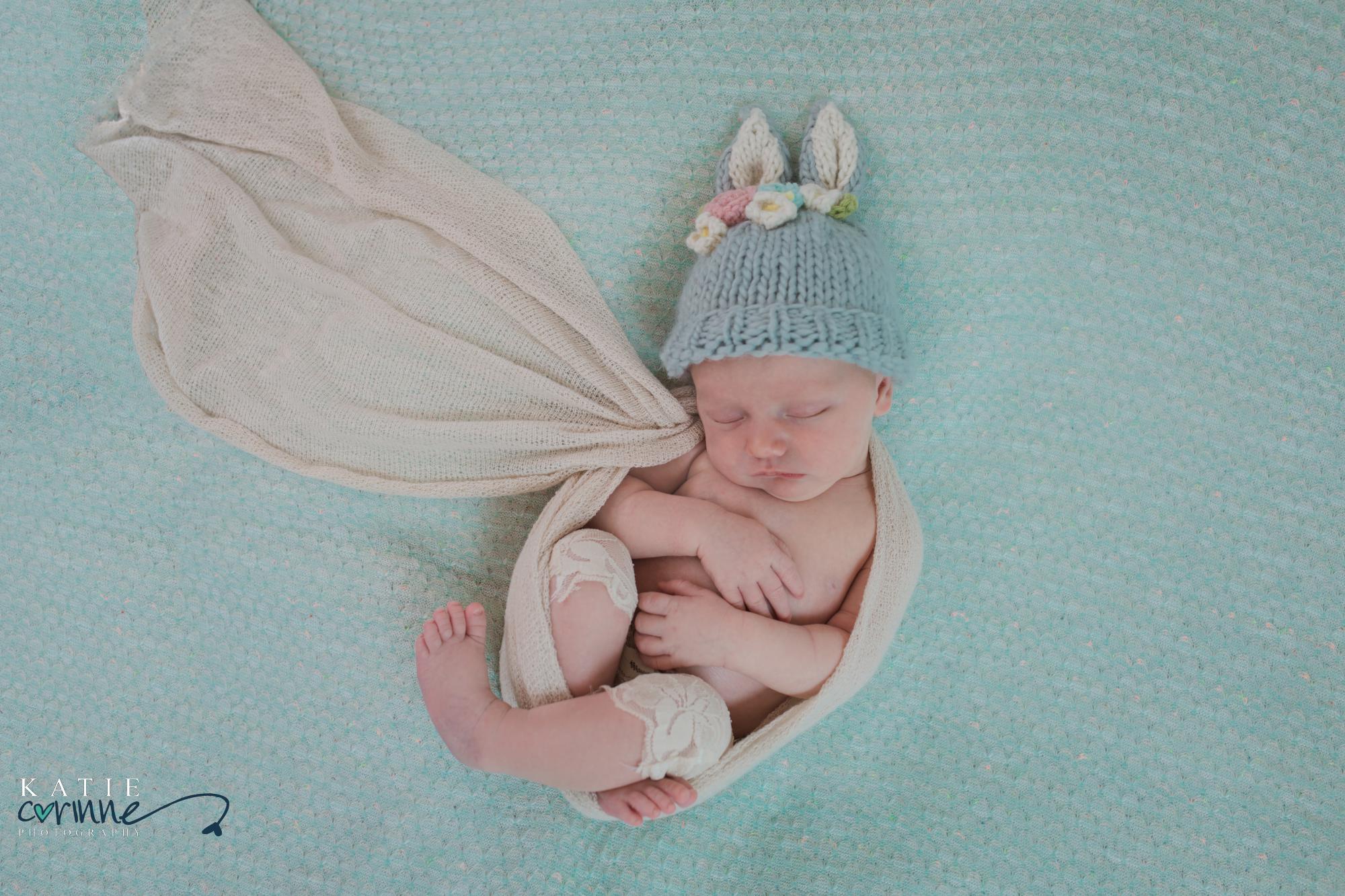 newborn baby girl wrapped up and posed for studio photo shoot