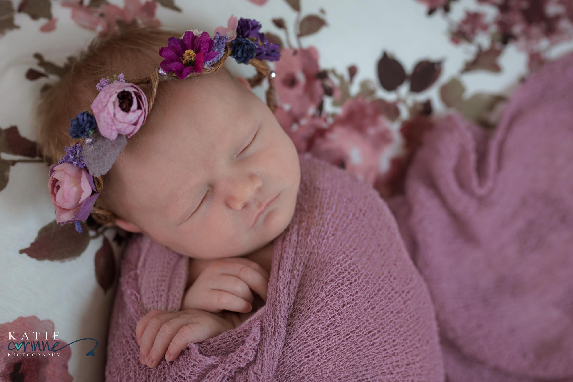 newborn baby girl wrapped in purple