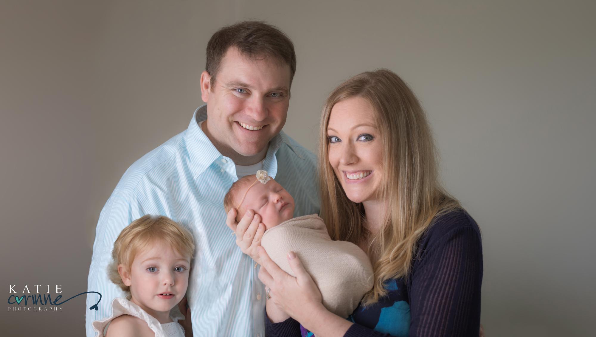 Family of four pose for destination newborn photographer