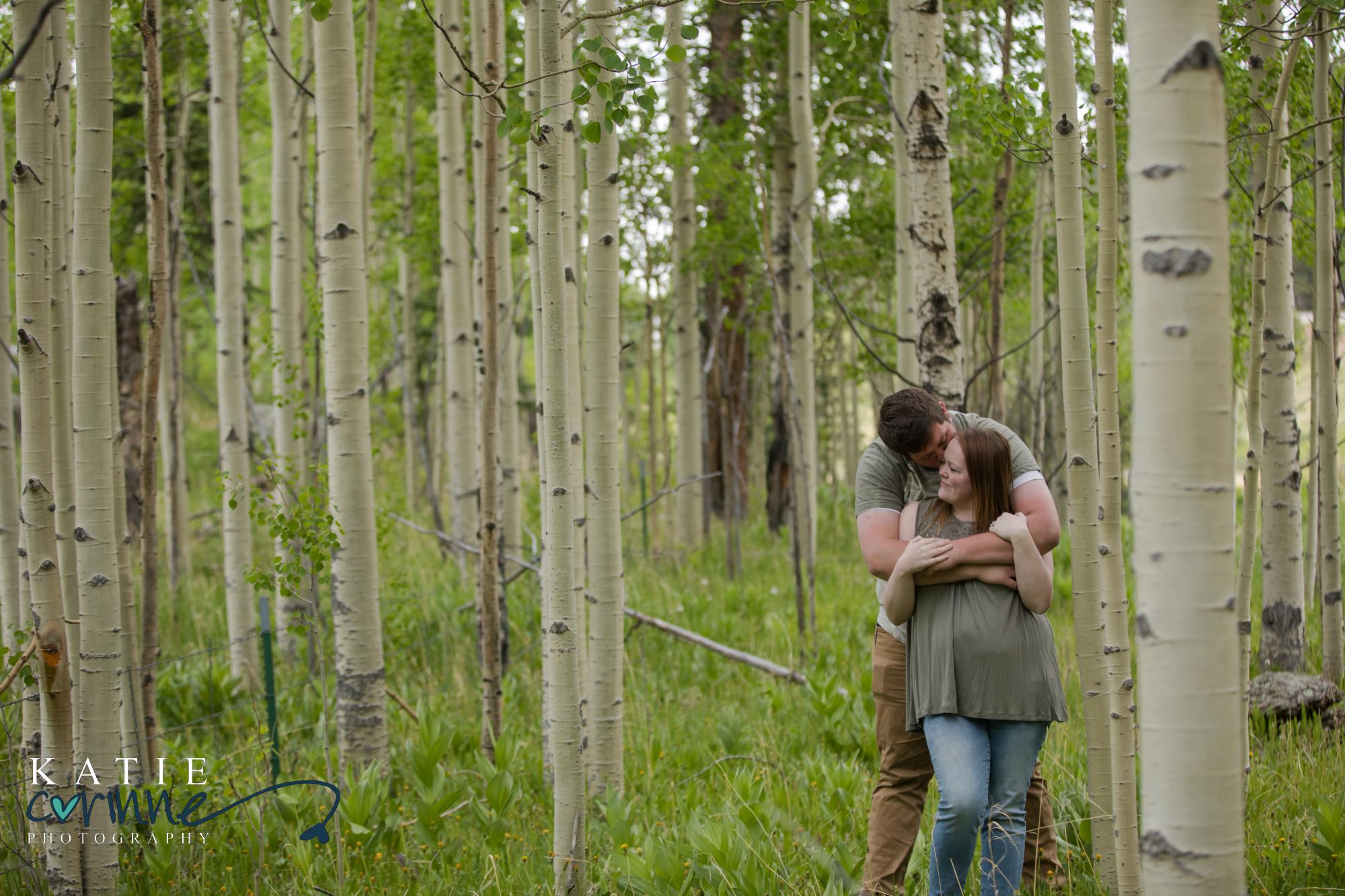 newly engaged couple cuddle in Colorado forest