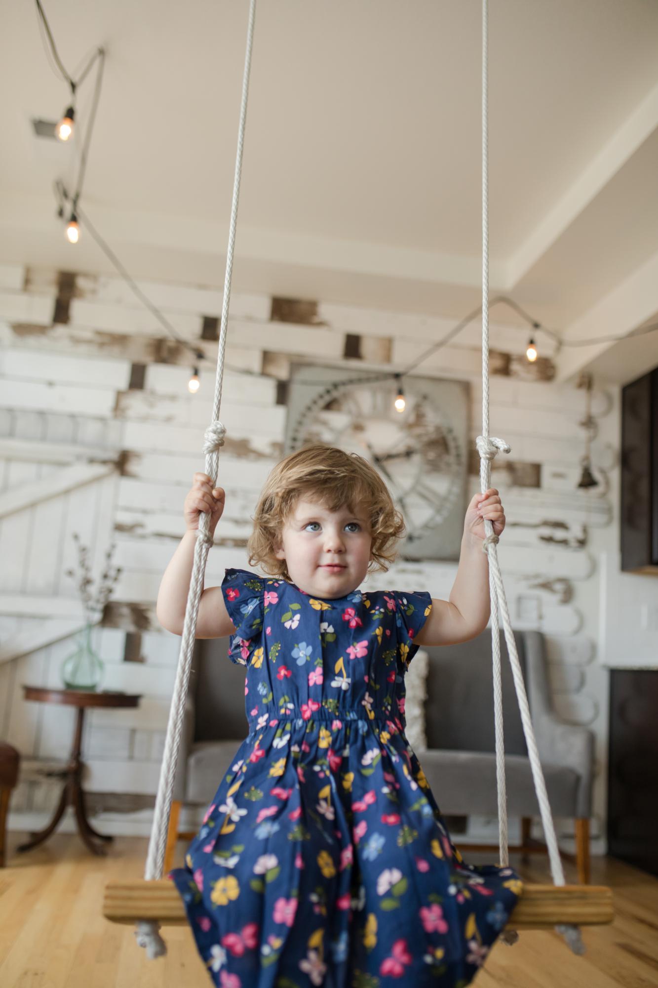 Young girl plays on swing in Colorado home
