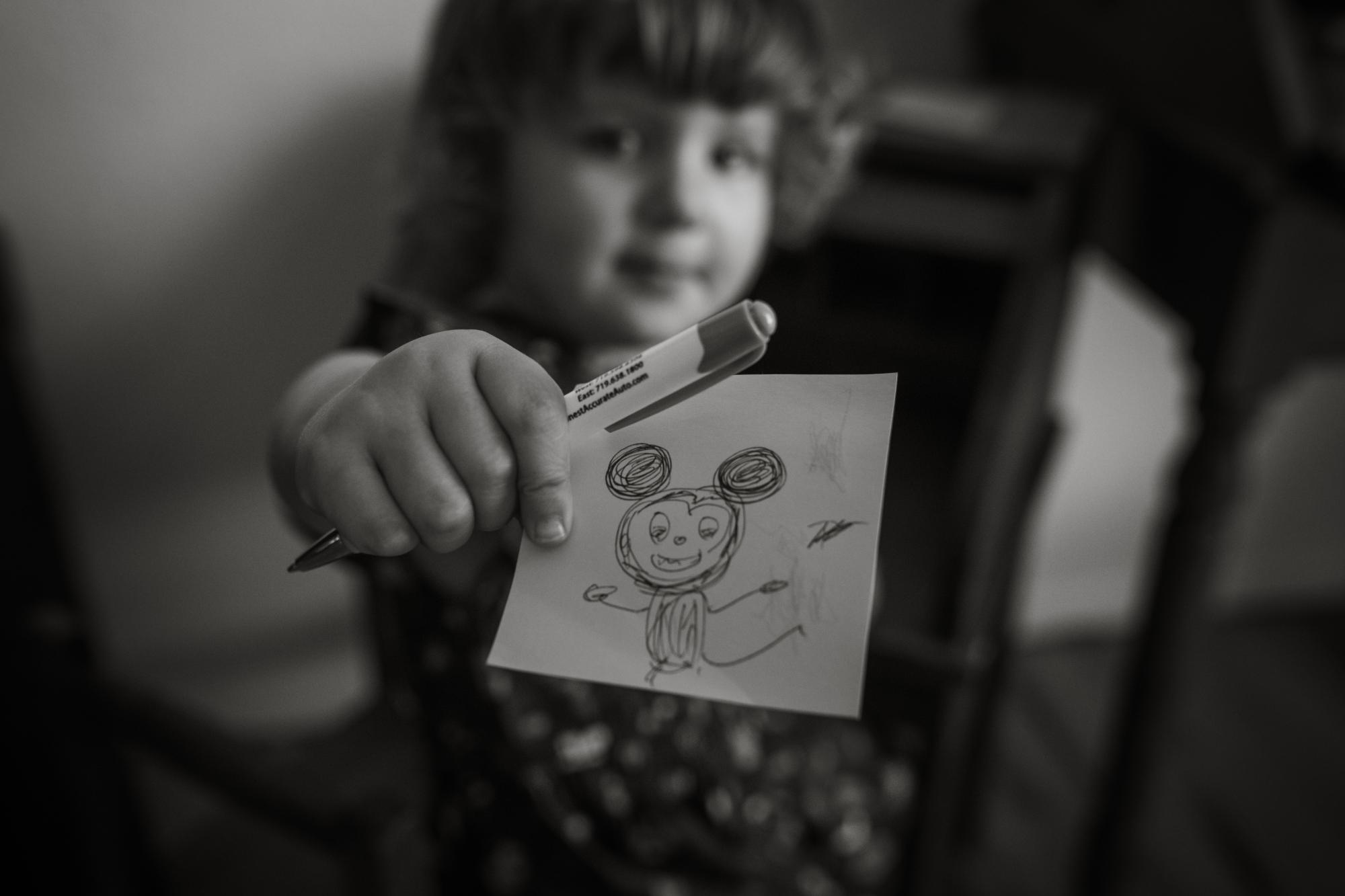 Colorado Springs kid shows drawing to documentary family photography