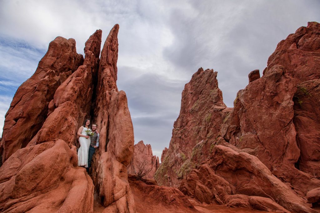 bride and groom standing on red rocks of garden of the gods