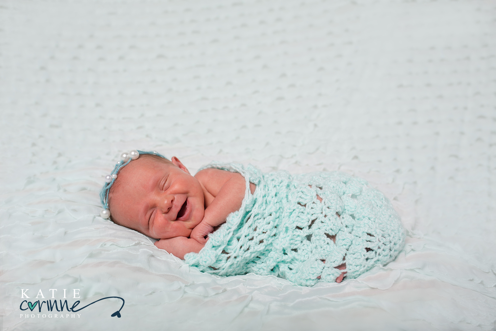 smiling newborn baby, newborn session, newborn photography session, newborn photos, baby photos, baby photography, teal crocheted newborn sack, beaded crown, 