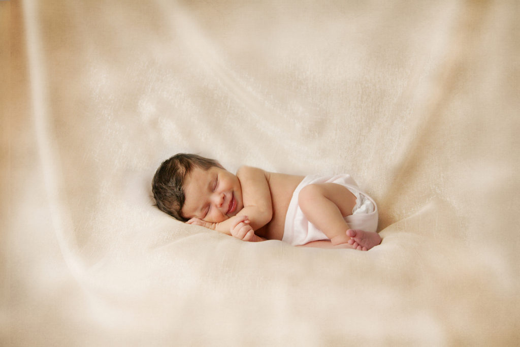 adorable newborn baby girl sleeping and smiling