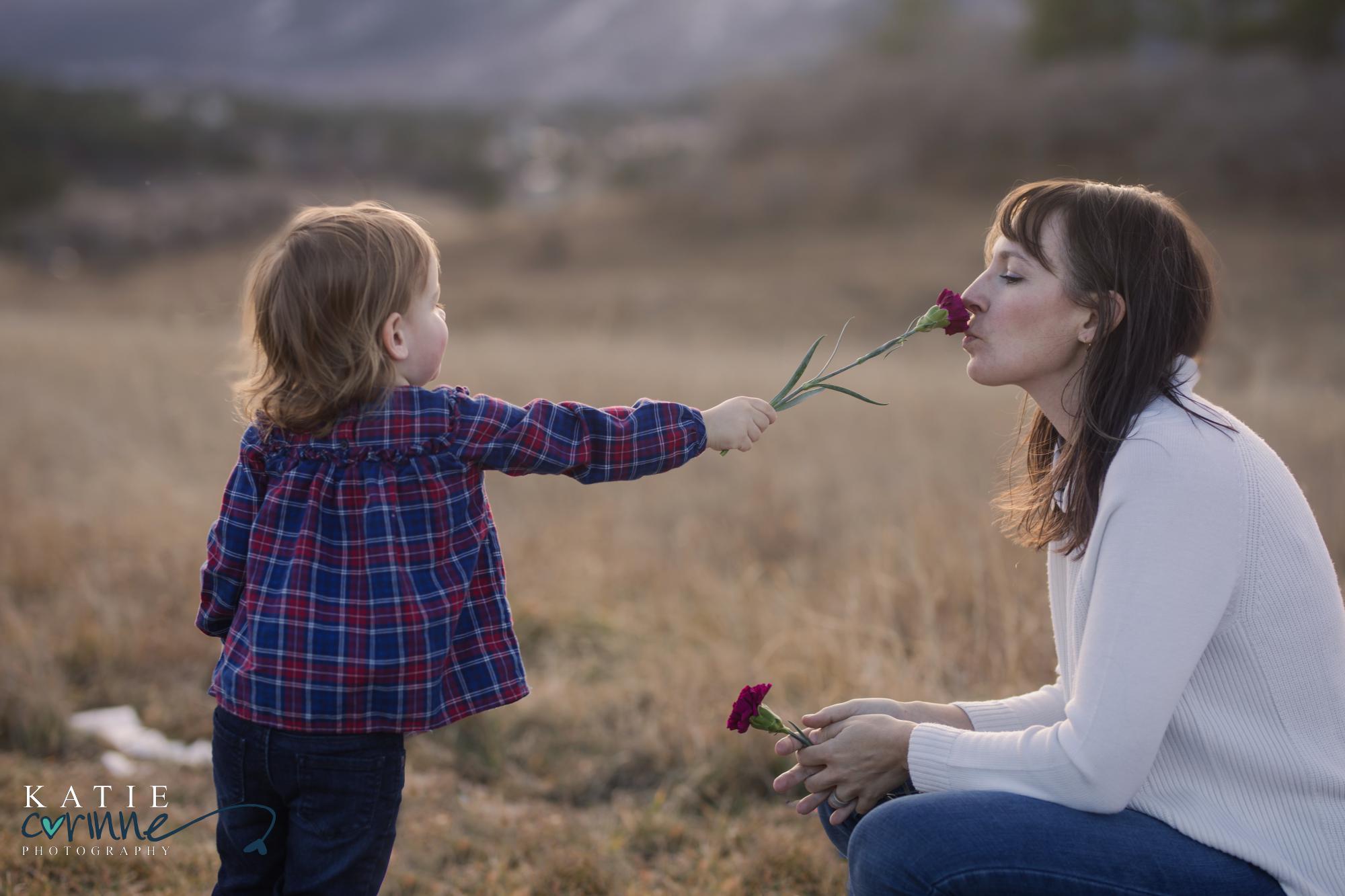 Child holds out flower for mother to smell in Colorado Springs