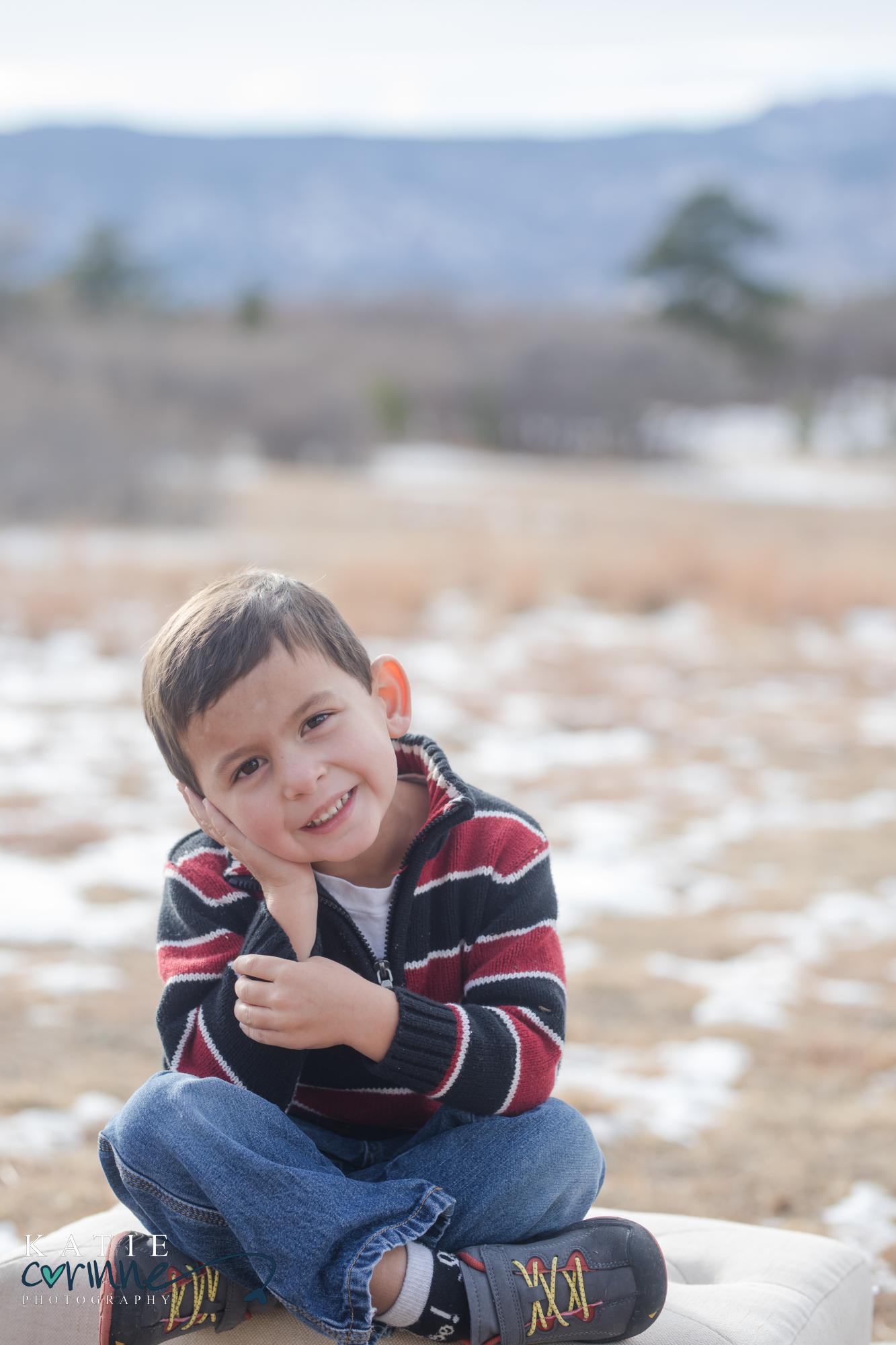 young boy poses and smiles at photography session