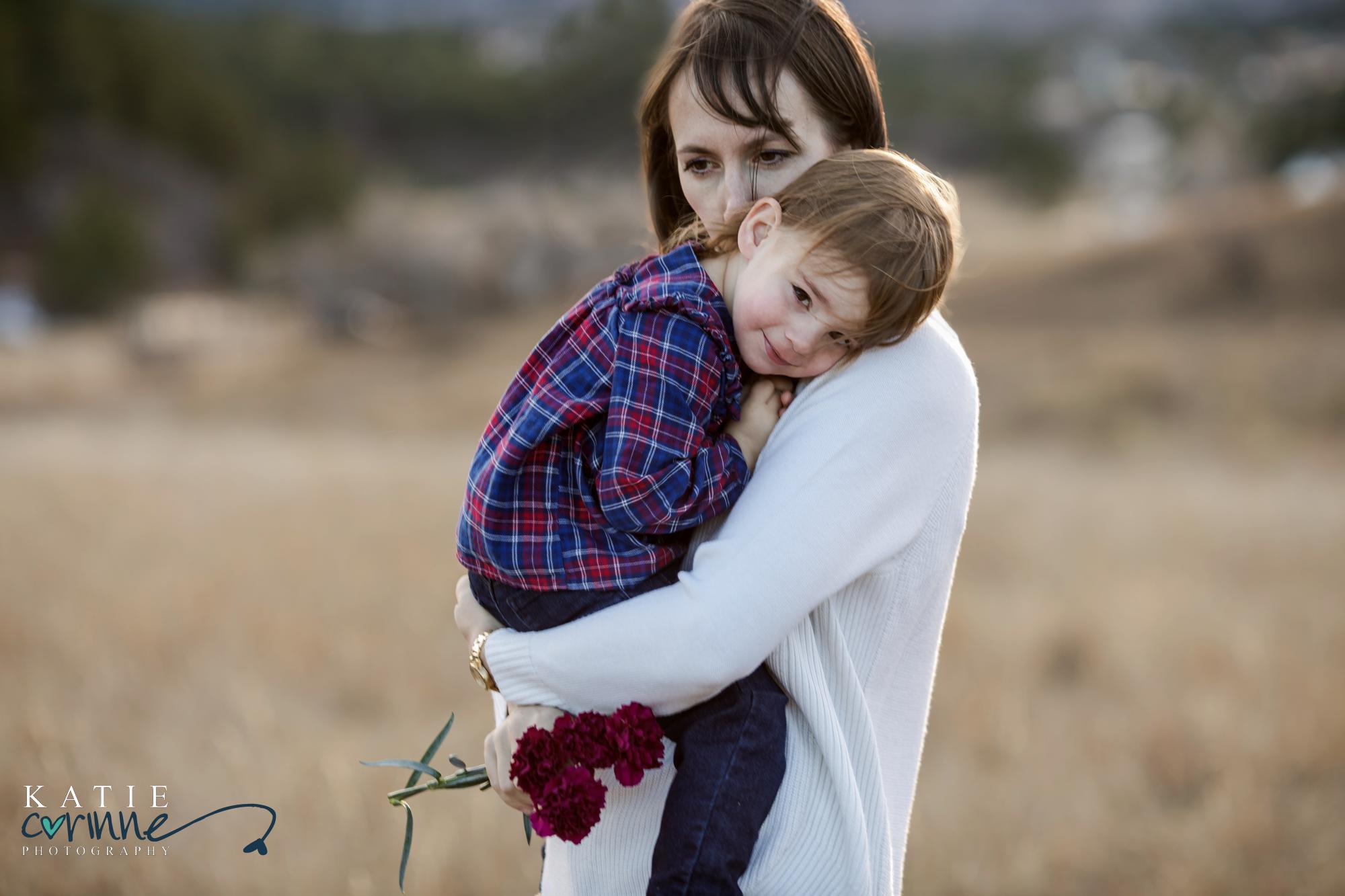 mother and daughter snuggle at outdoor photography session