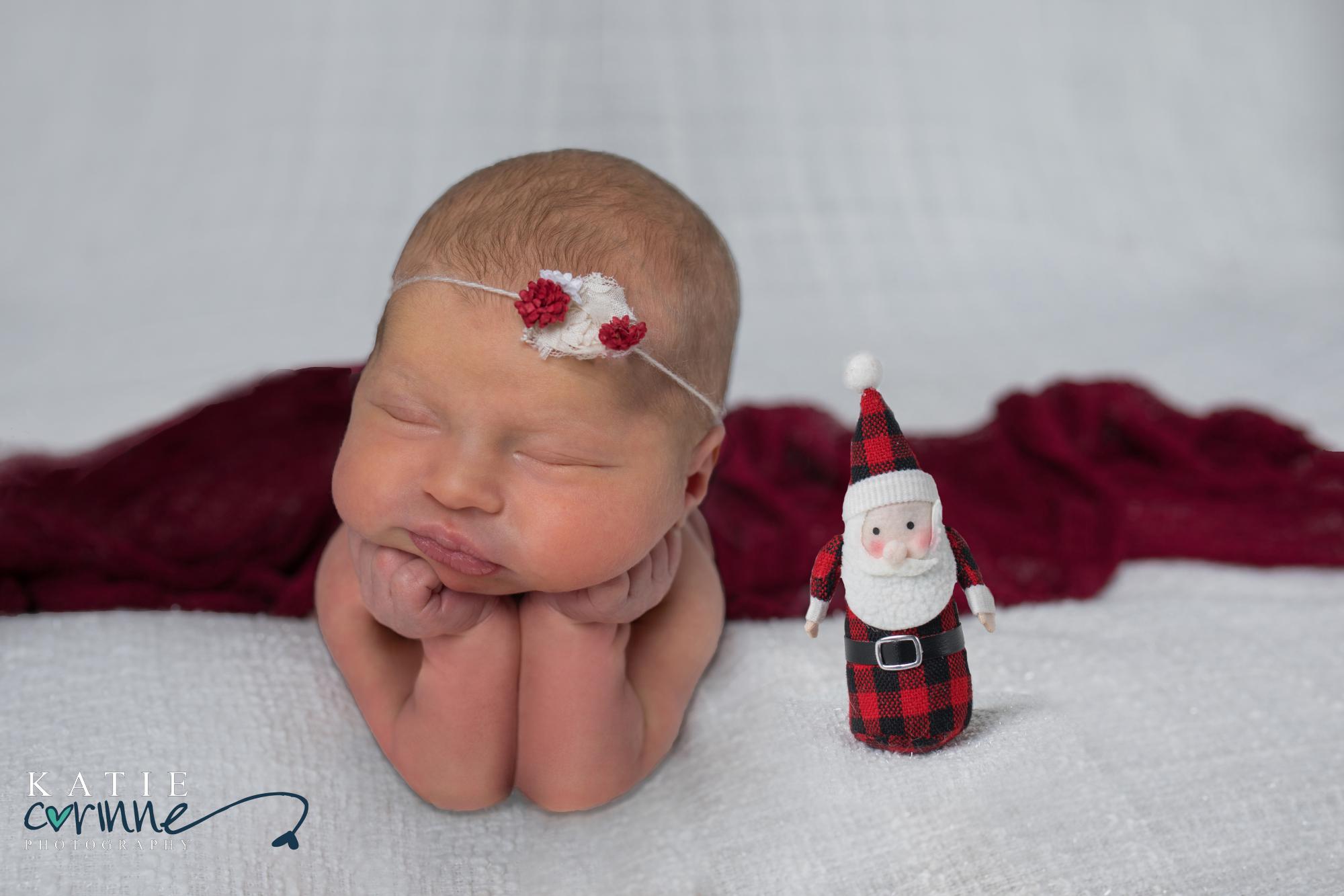 baby girl posing next to santa doll