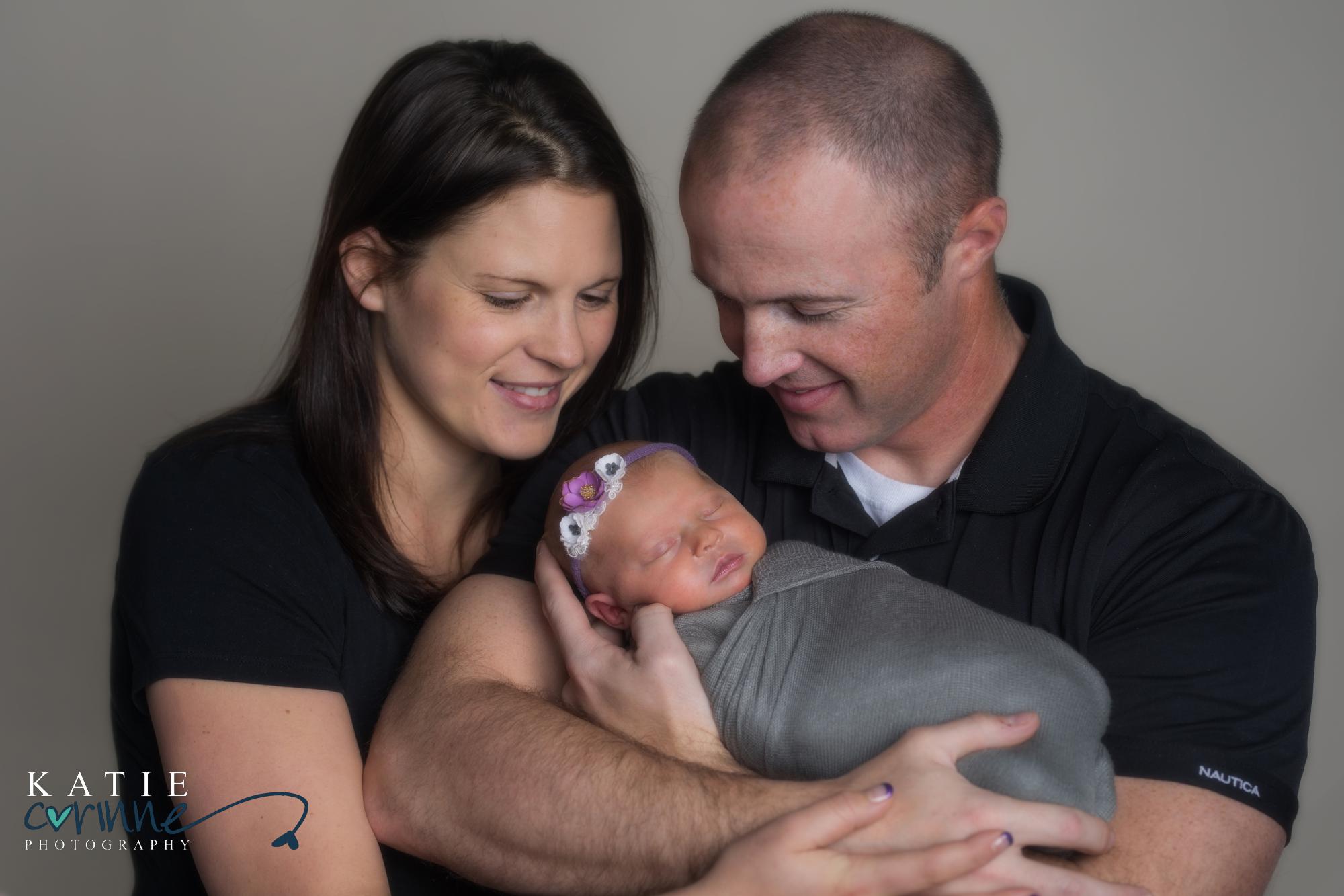 new parents hold baby daughter