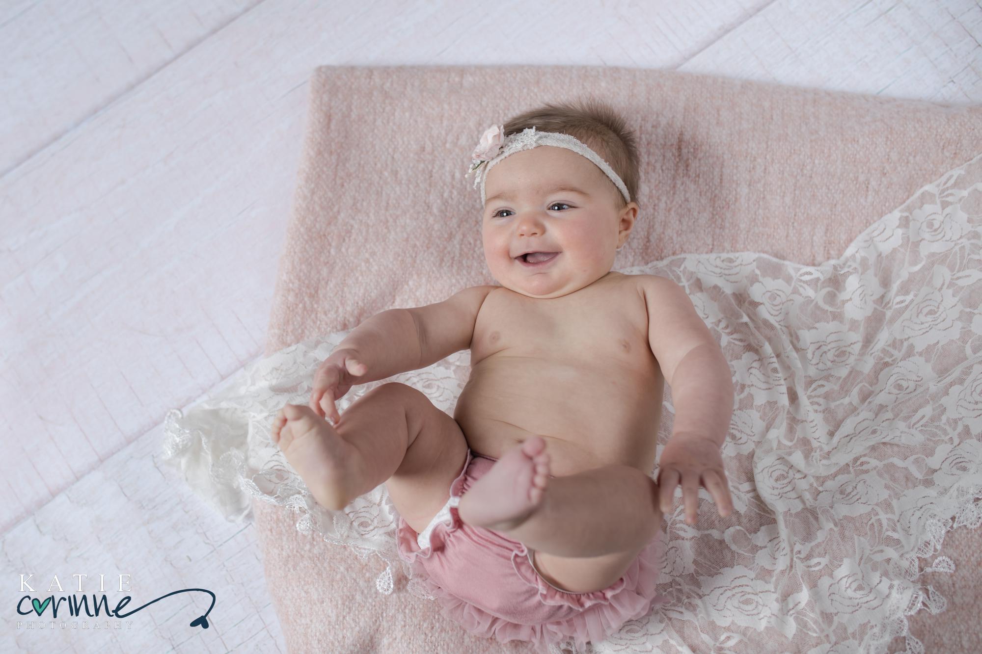 baby plays with her feet at a colorado portratis studio