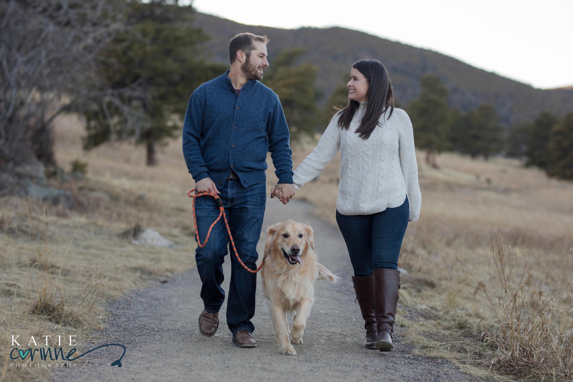 engaged couple walk their dog in Evergreen