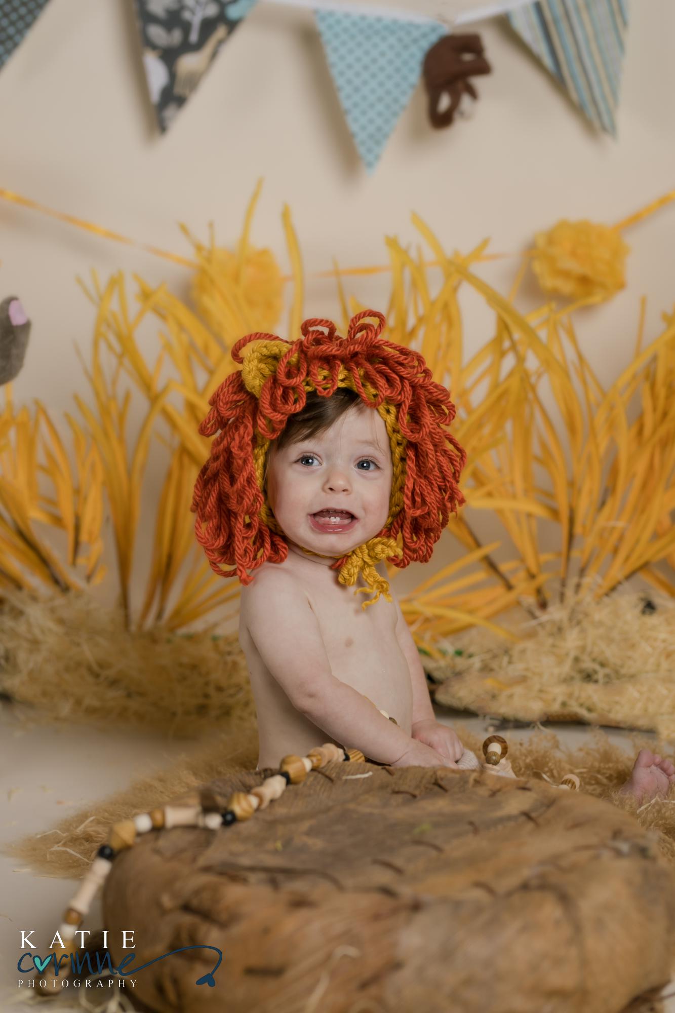 one year old boy poses in lion bonnet