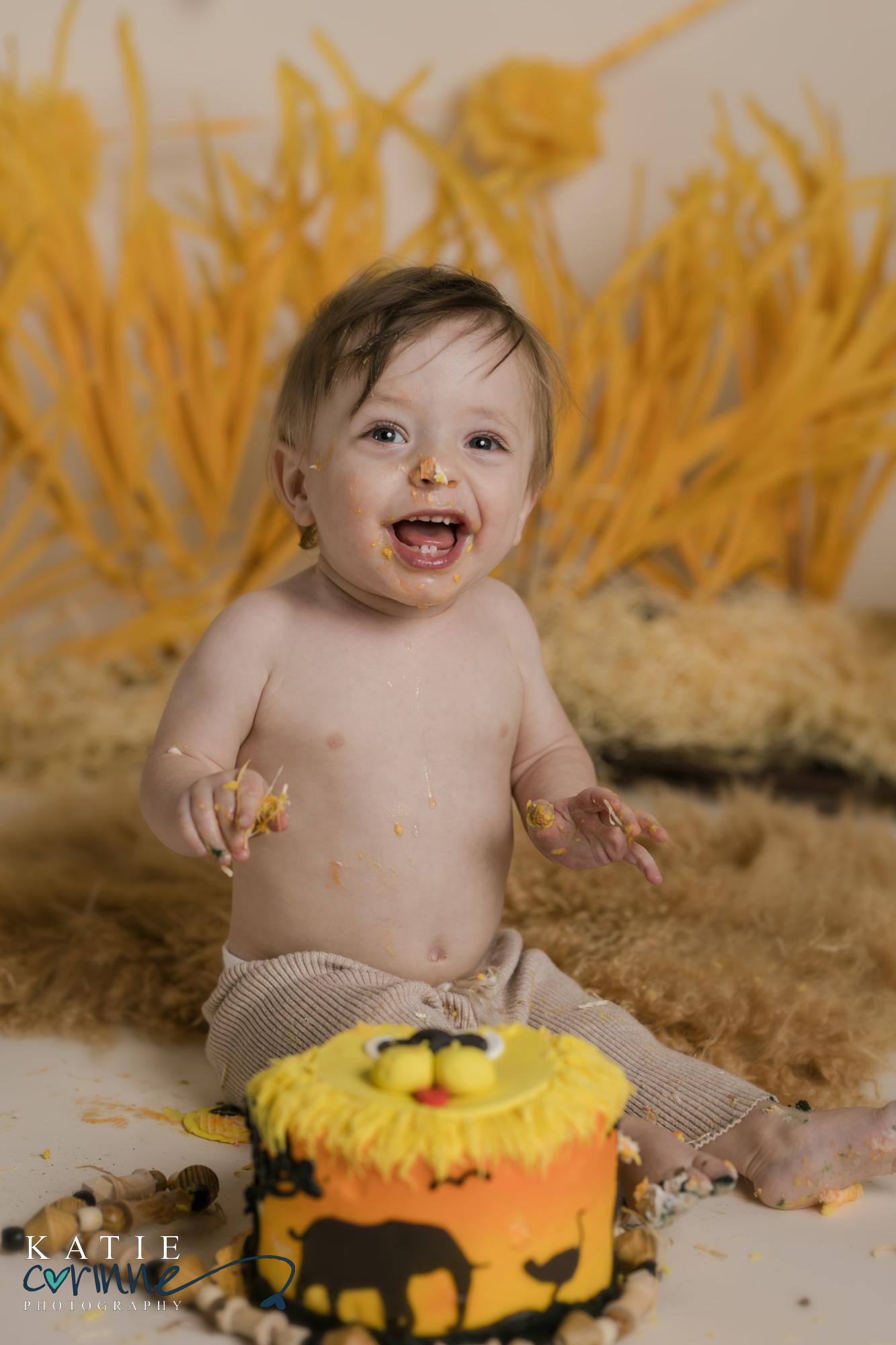 one year old baby poses with his birthday smash cake