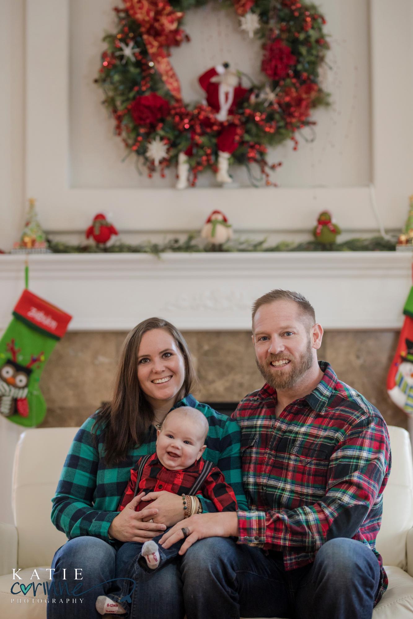 young family of three wears plaid and sits on couch
