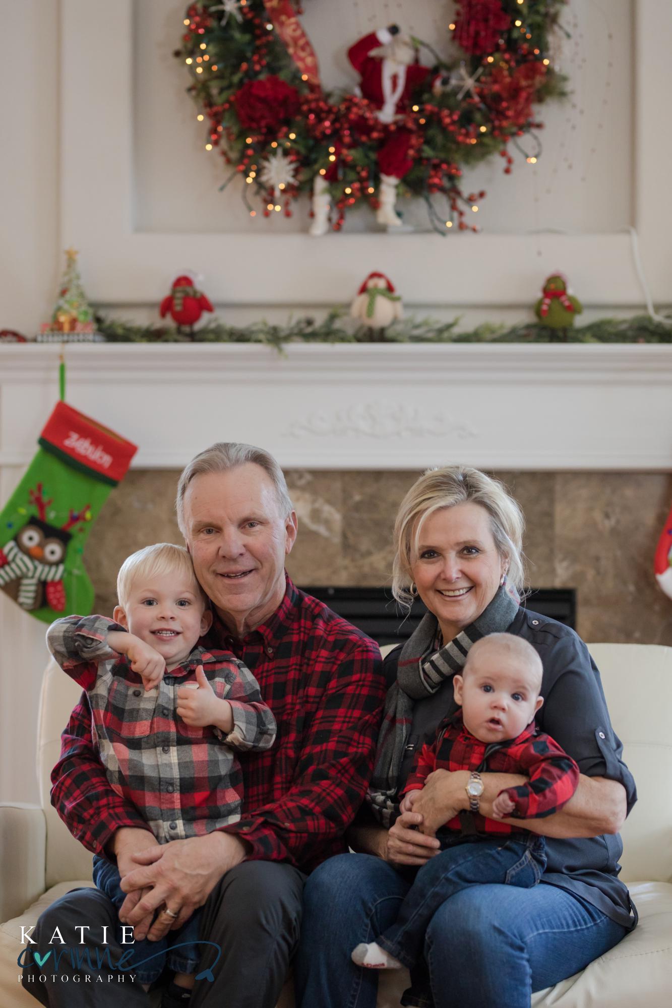 older couple pose with their young grandchildren in their home