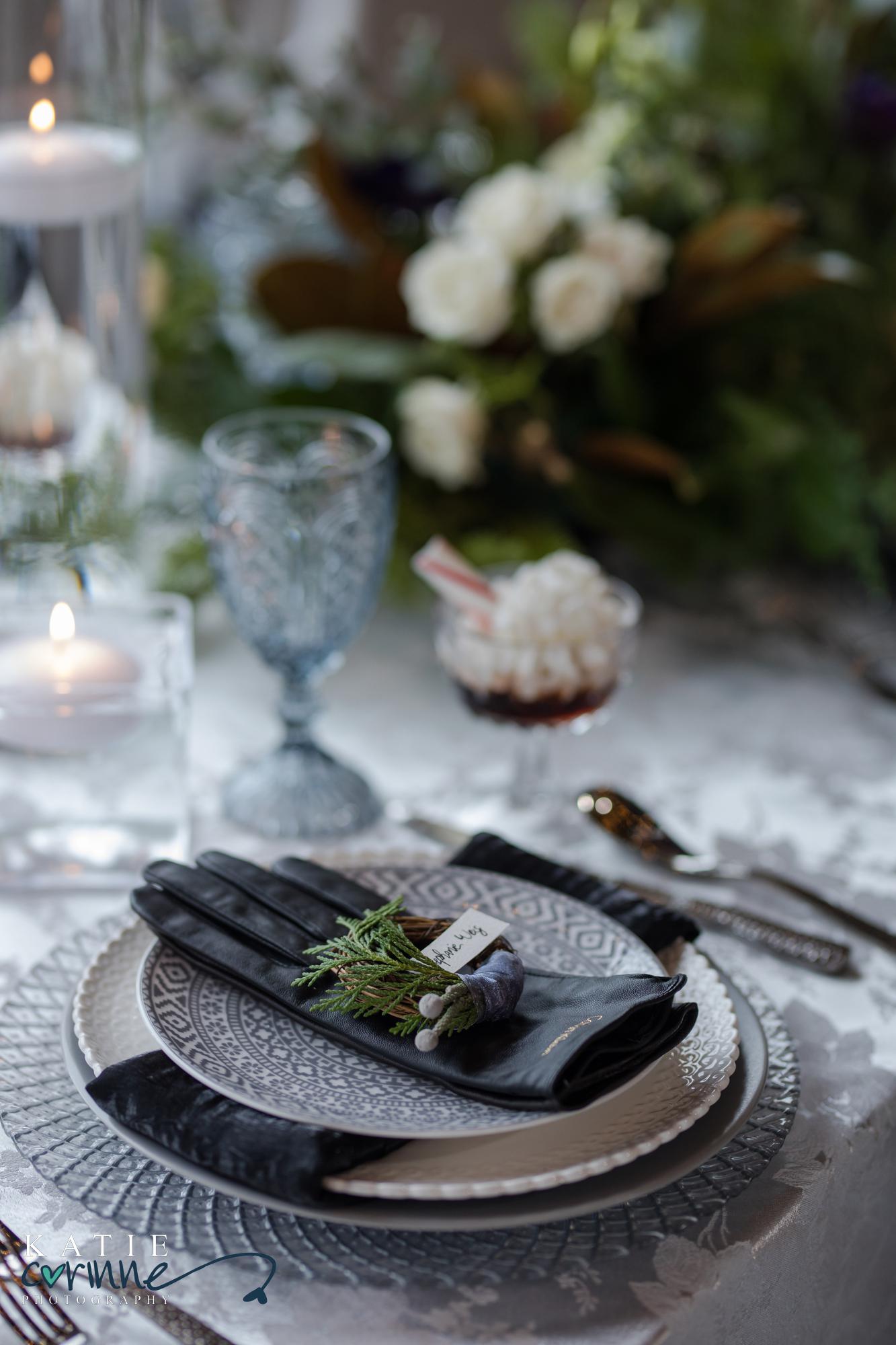 Gloves sit on top of place setting with tiny wreath placecard