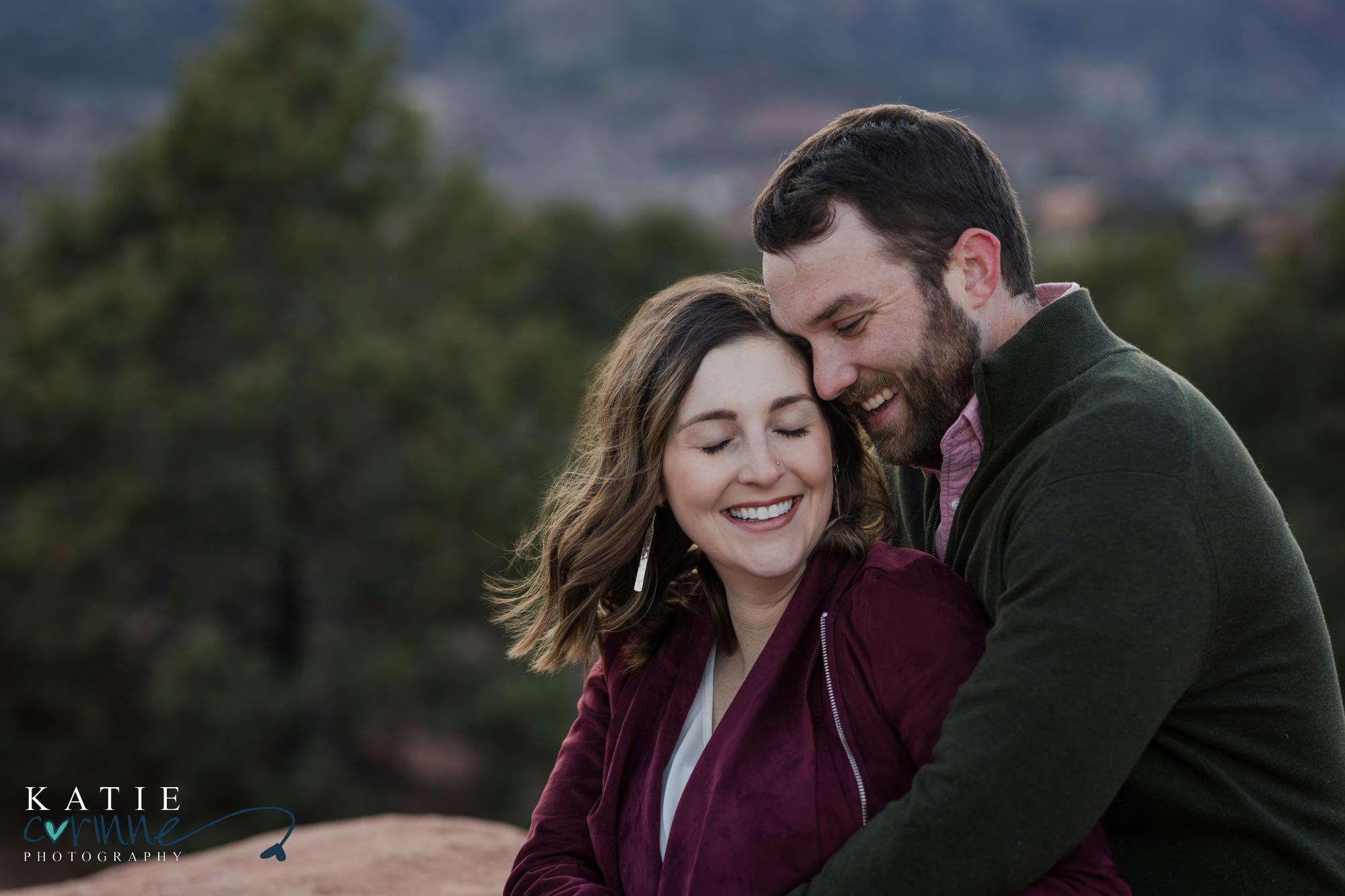 couple engaged on mountain cuddling