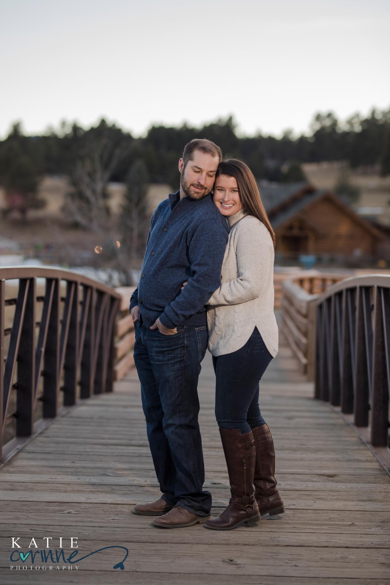 engaged couple on bridge in Colorado mountain town