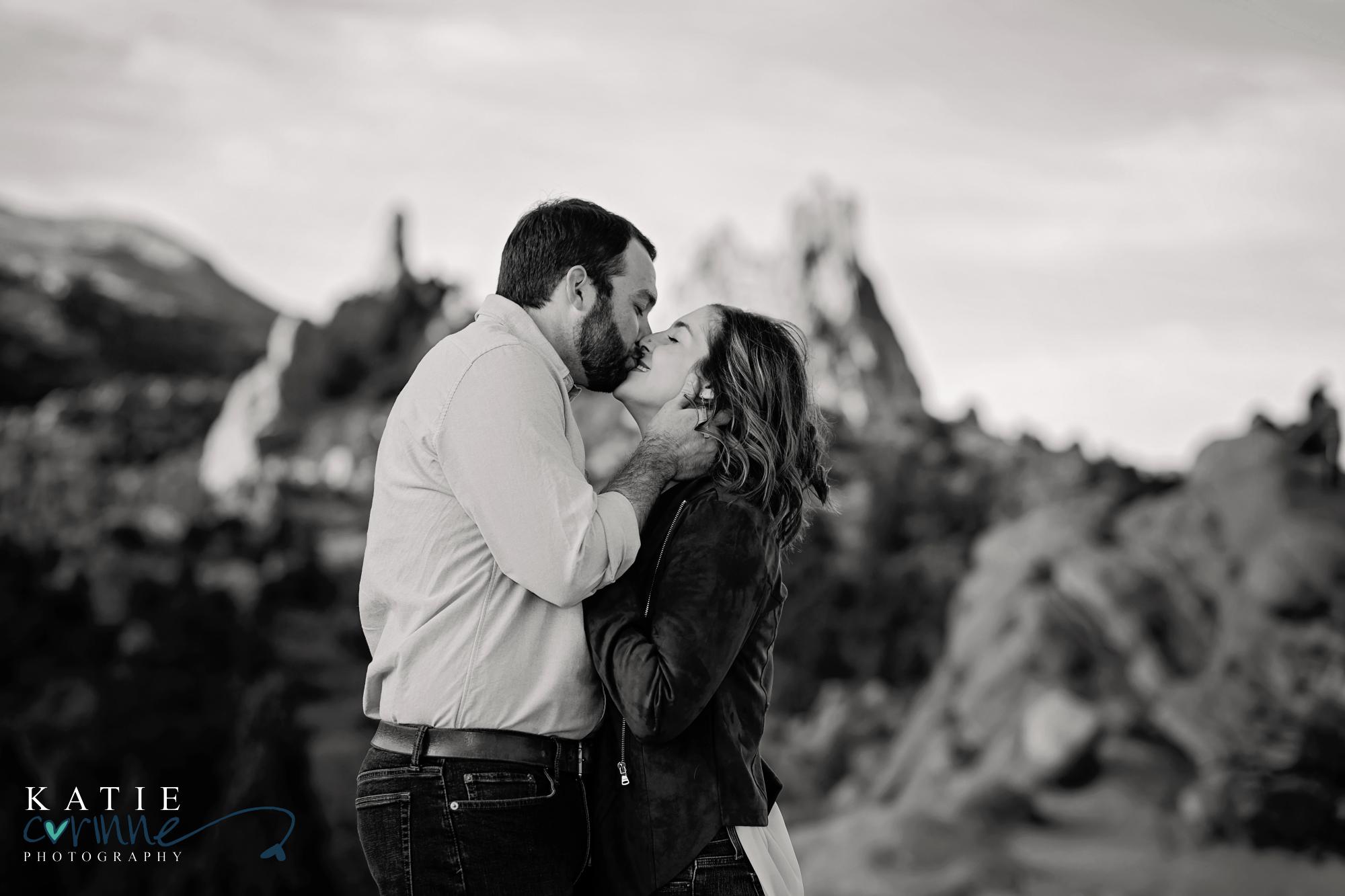 black and white photo of couple kissing in garden of the gods