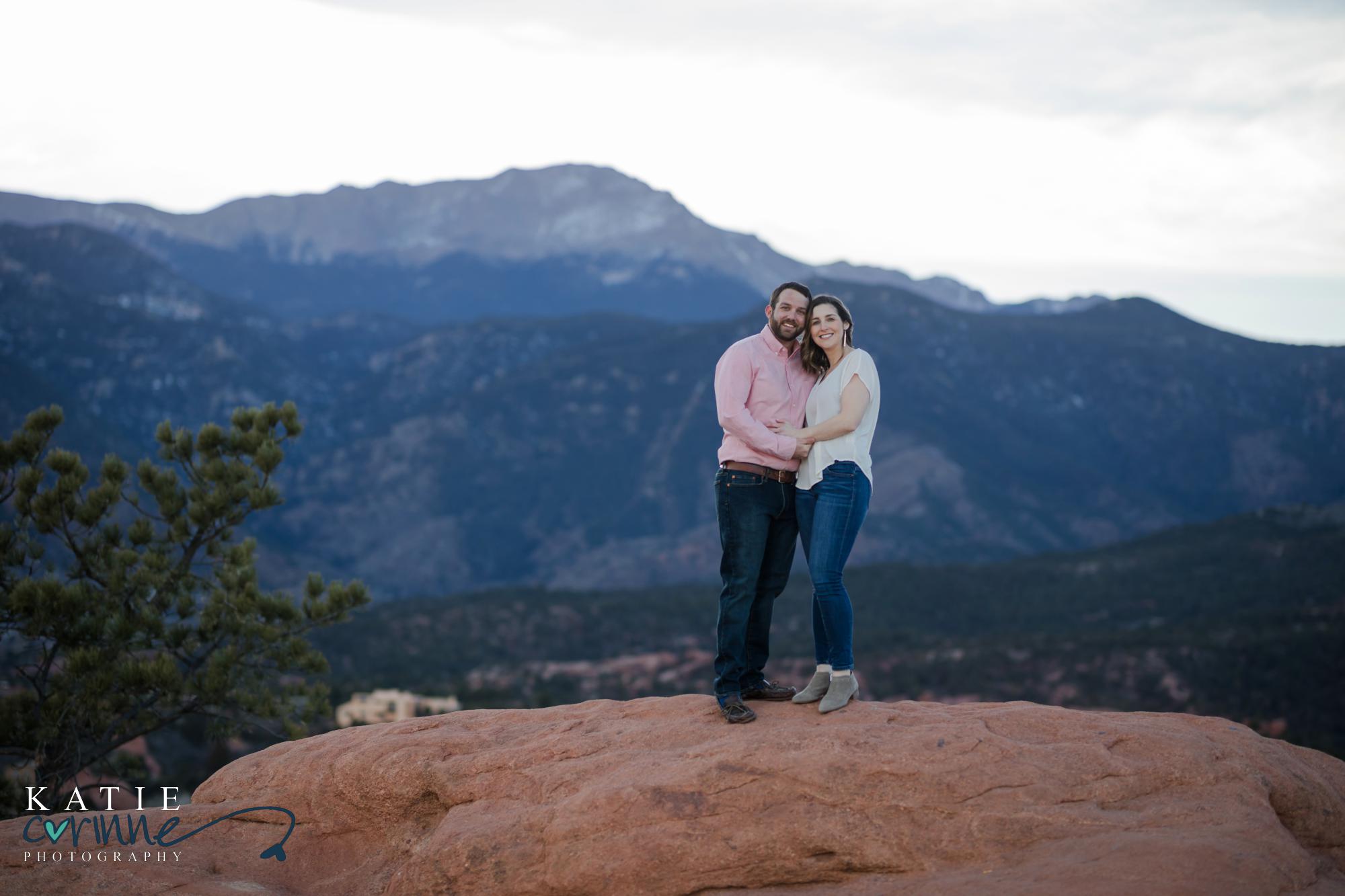engaged couple in front of mountain range in winter
