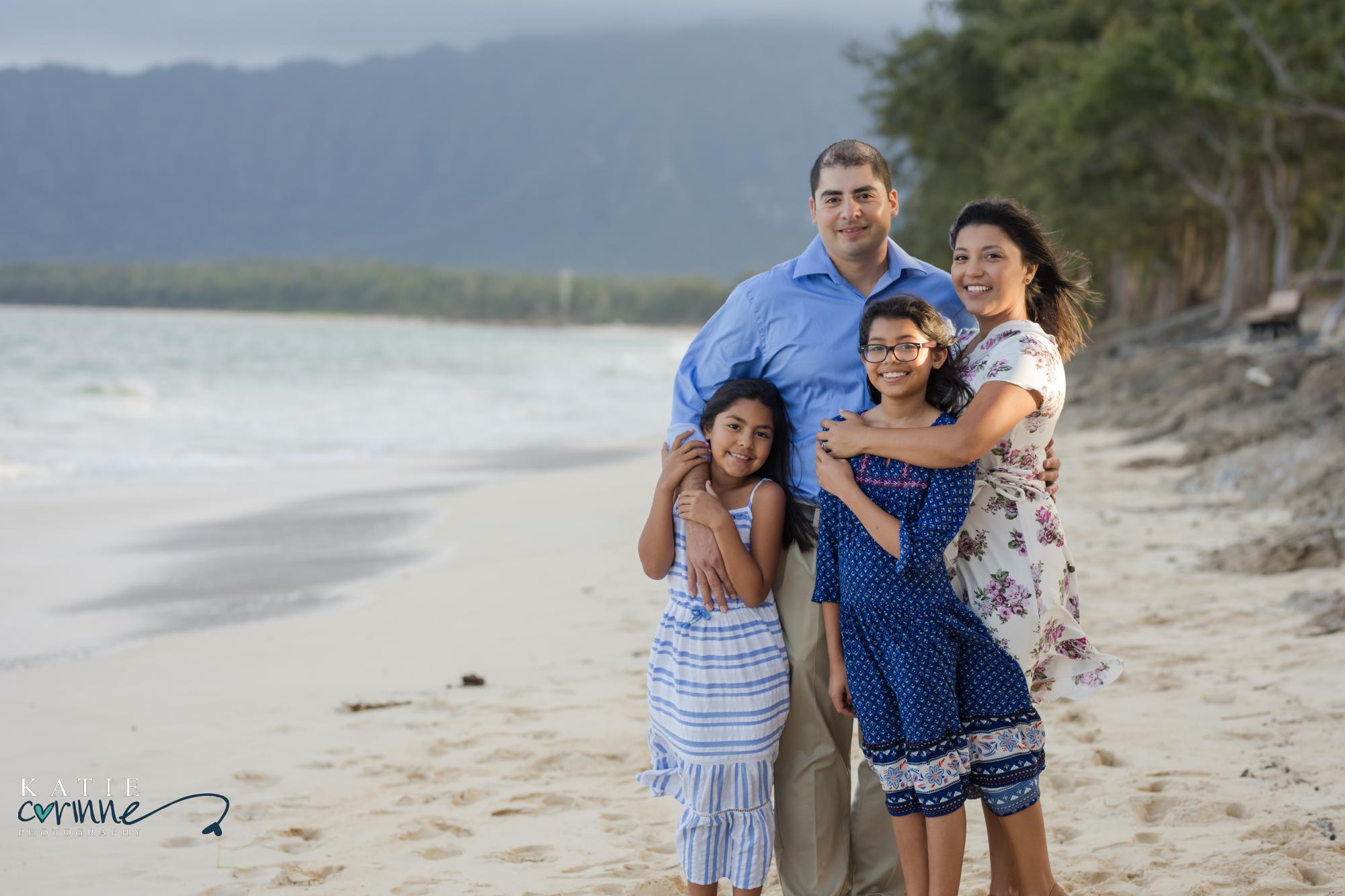 family poses for photography session on beach in hawaii