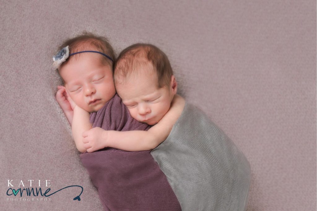 Newborn twins cuddling together