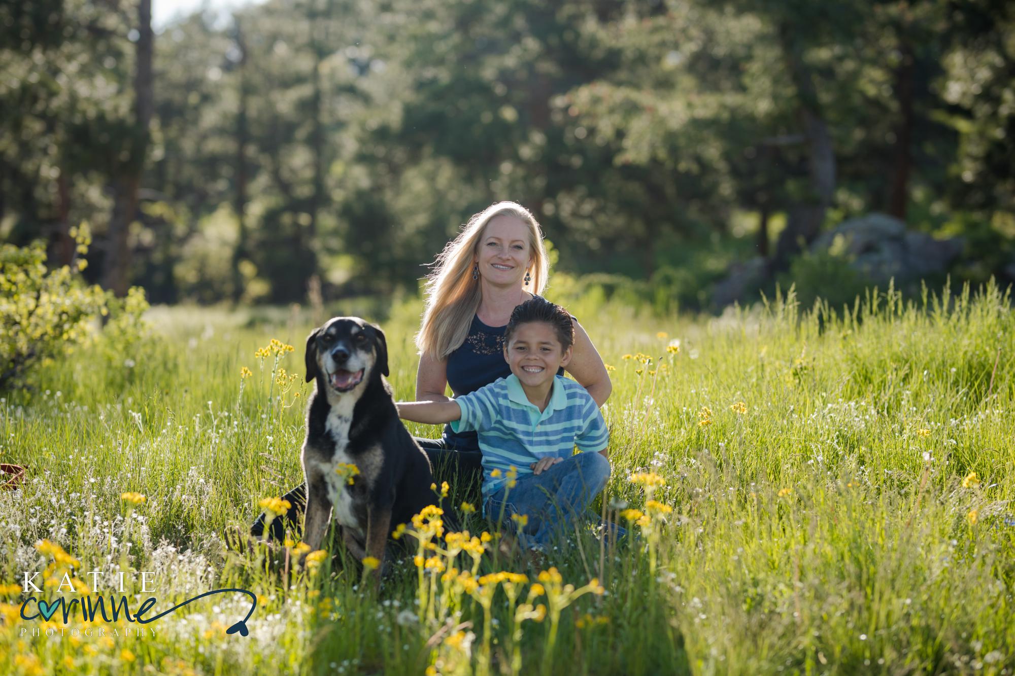 Family poses for summer photos in a field