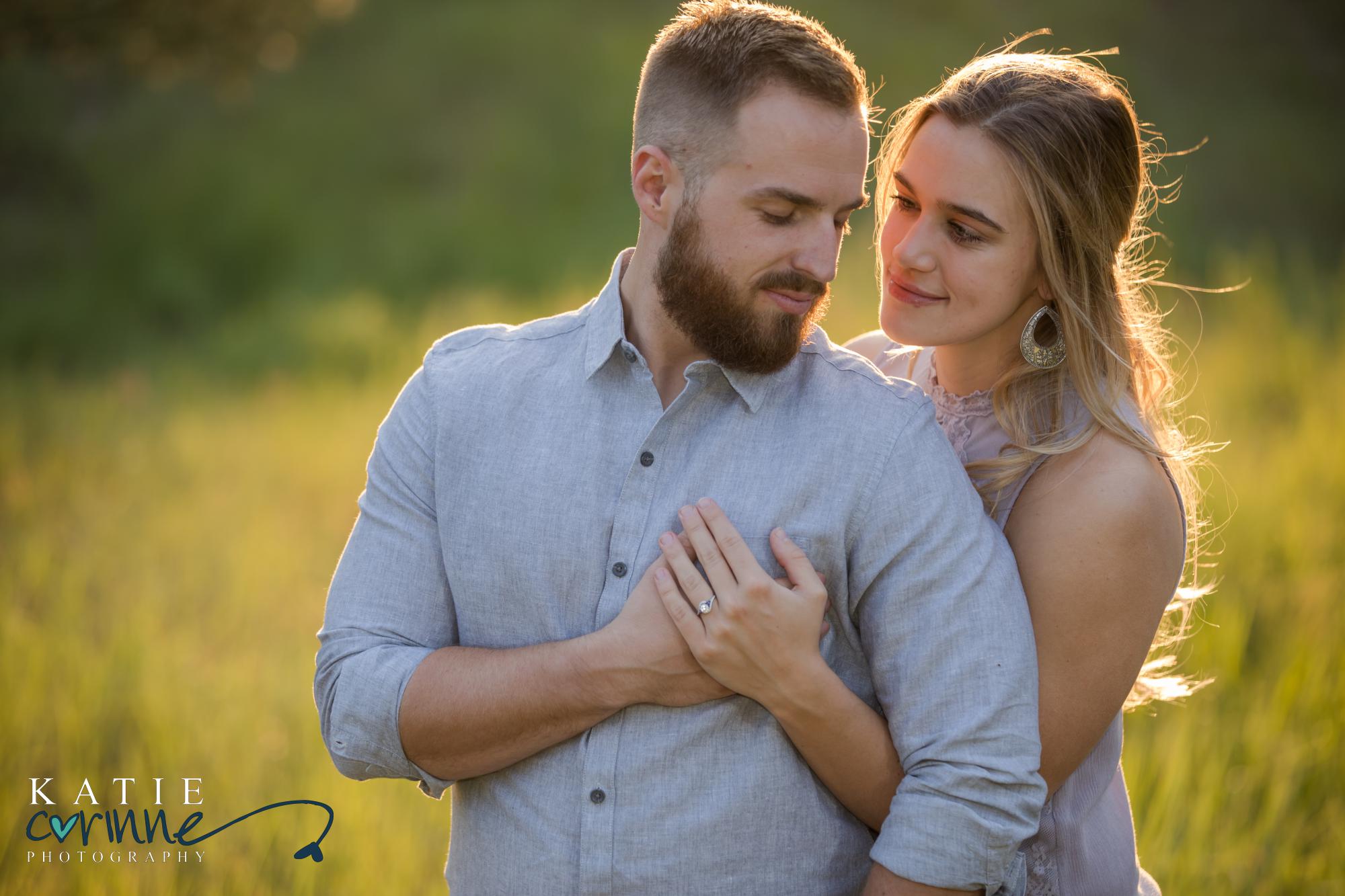 Engaged couple poses in family backyard