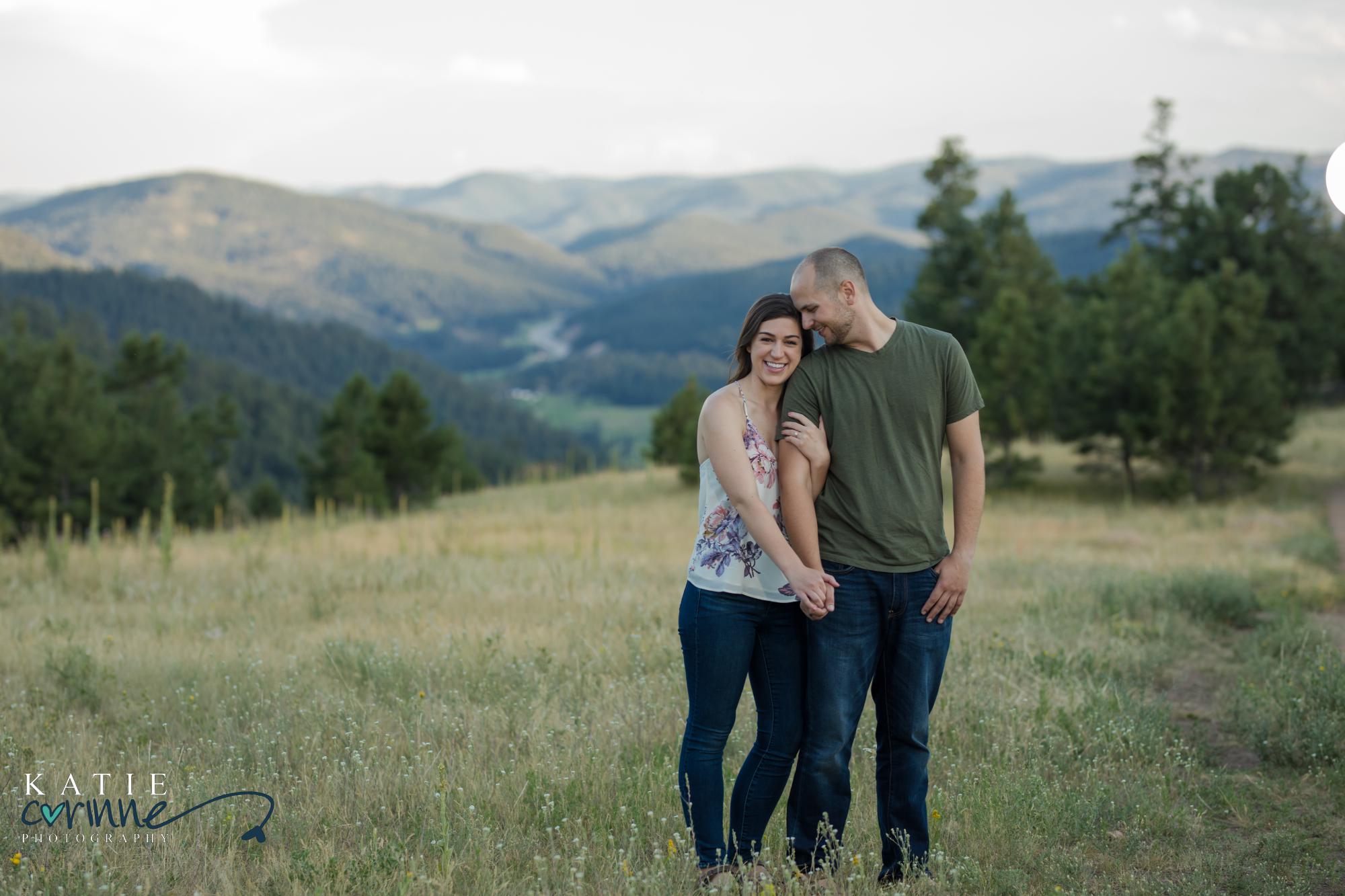 newly engaged couple in front of rocky mountains