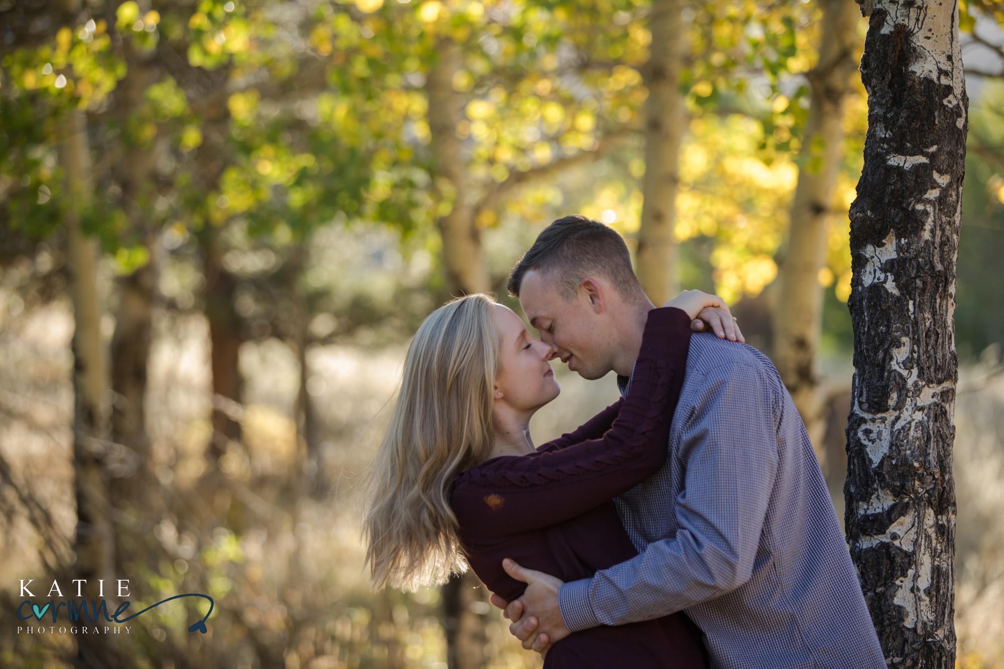engaged couple in front of fall leaves