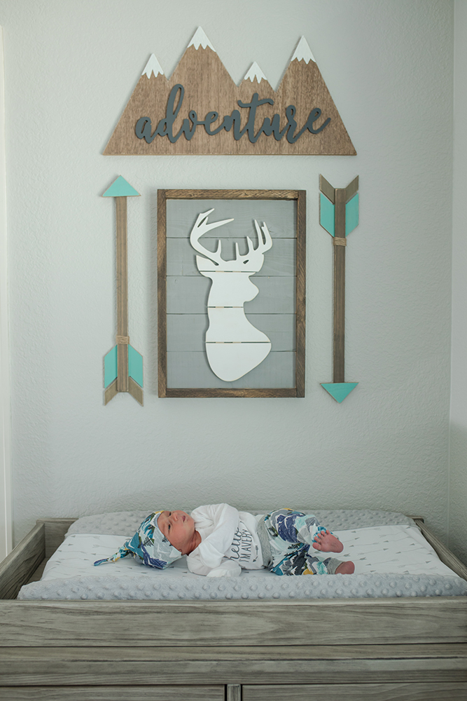 Newborn baby in nursery with wall decor