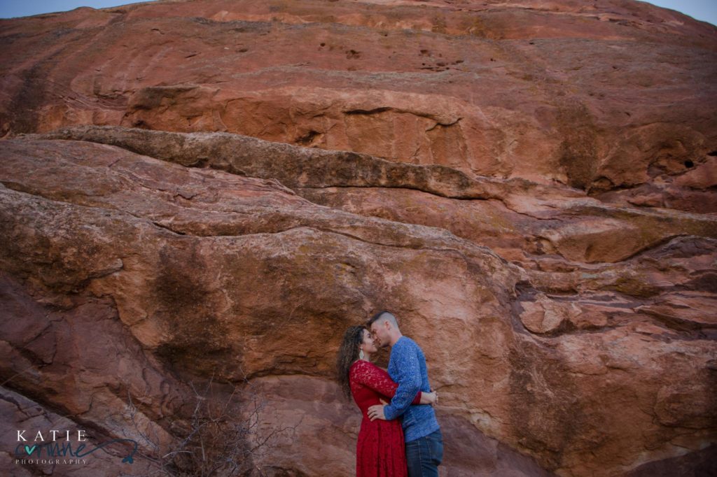 engaged couple in front of Colorados red rocks