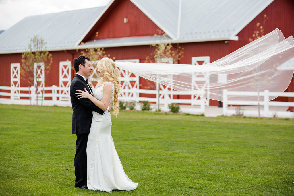 Bride and Groom hugging in front of a red barn