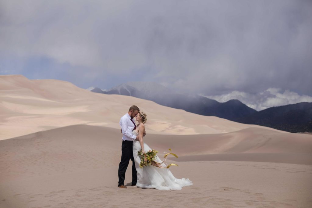 Day after wedding couple kiss on sand dunes
