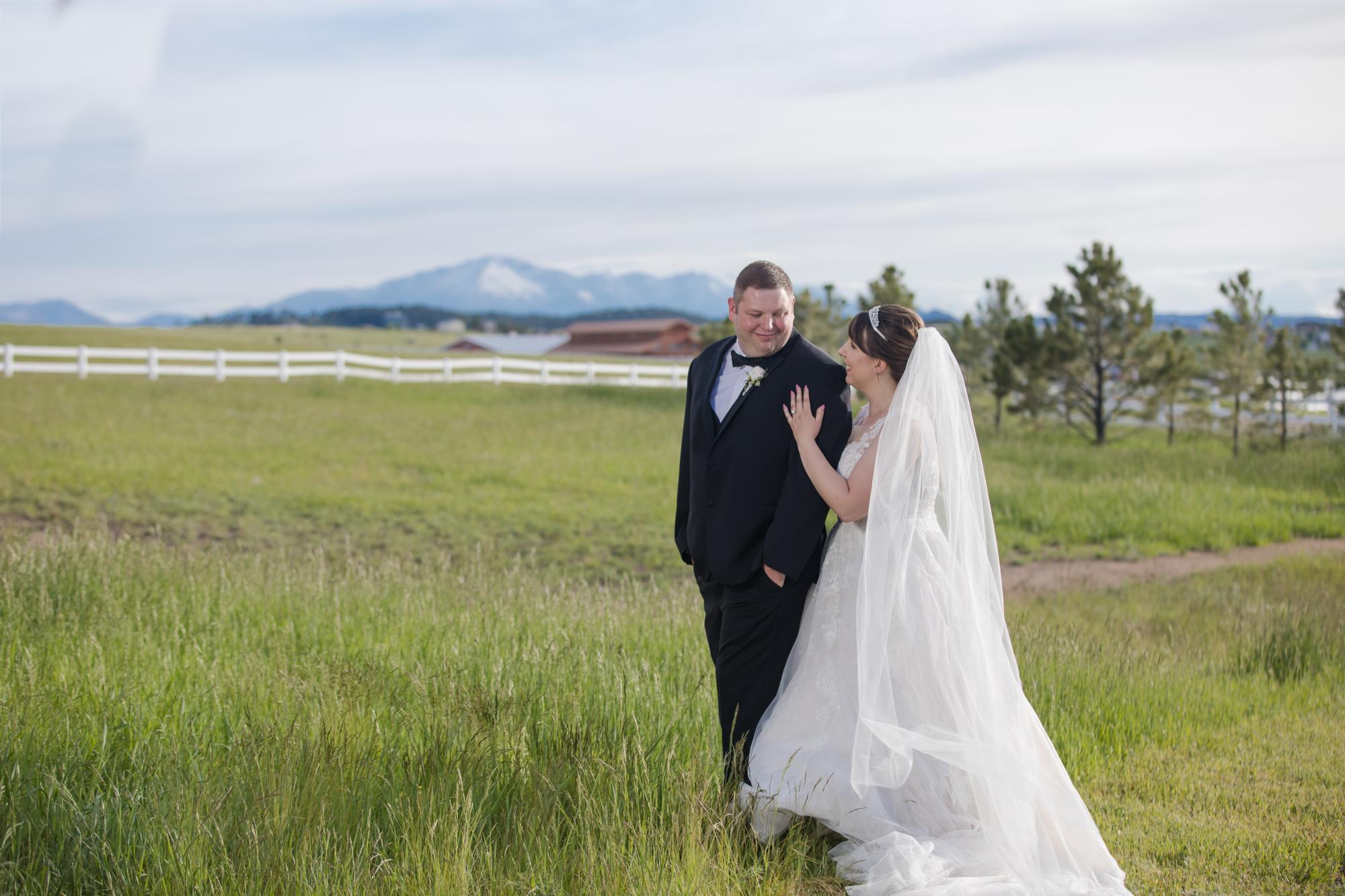 bride and groom walk through field after Flying Horse wedding ceremony