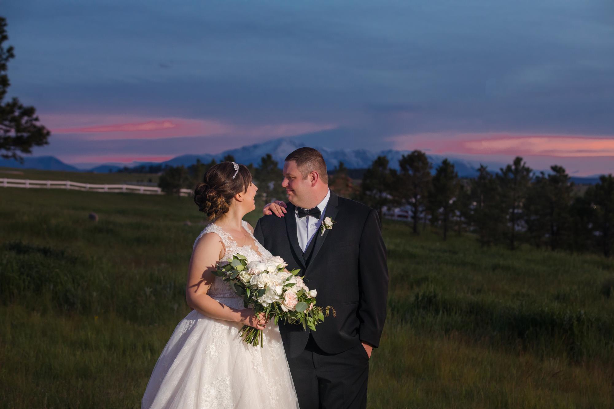 wedding couple with bouquet in front of beautiful sunset