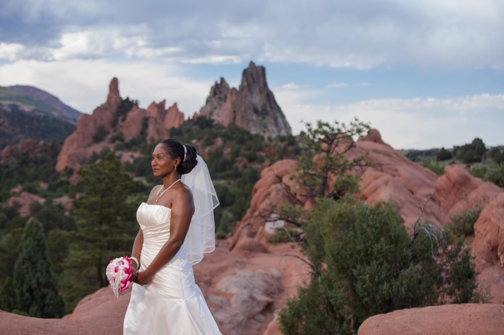 bride stands in Garden of the Gods at sunset