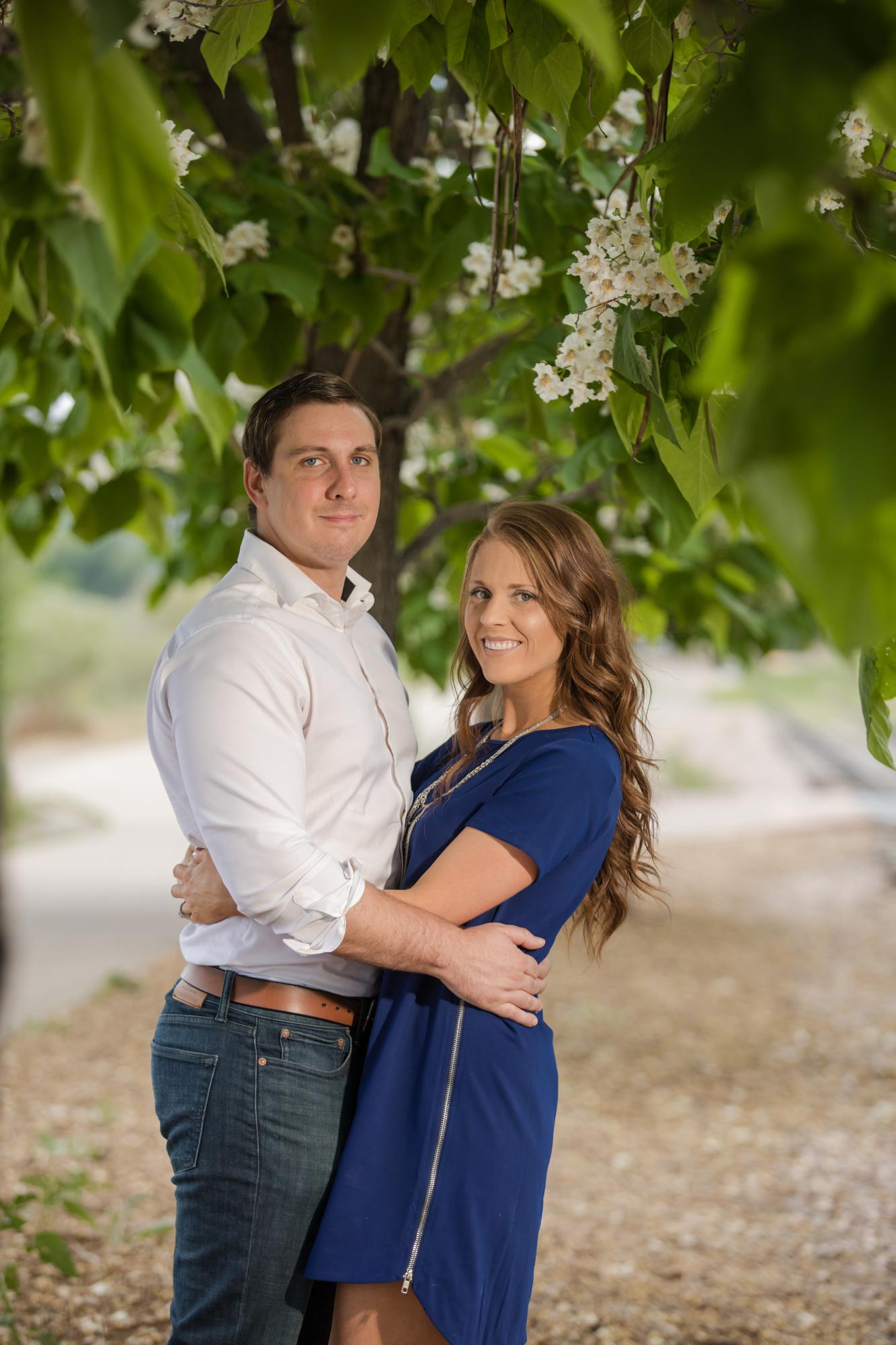 Couple pose in garden for engagement photographer