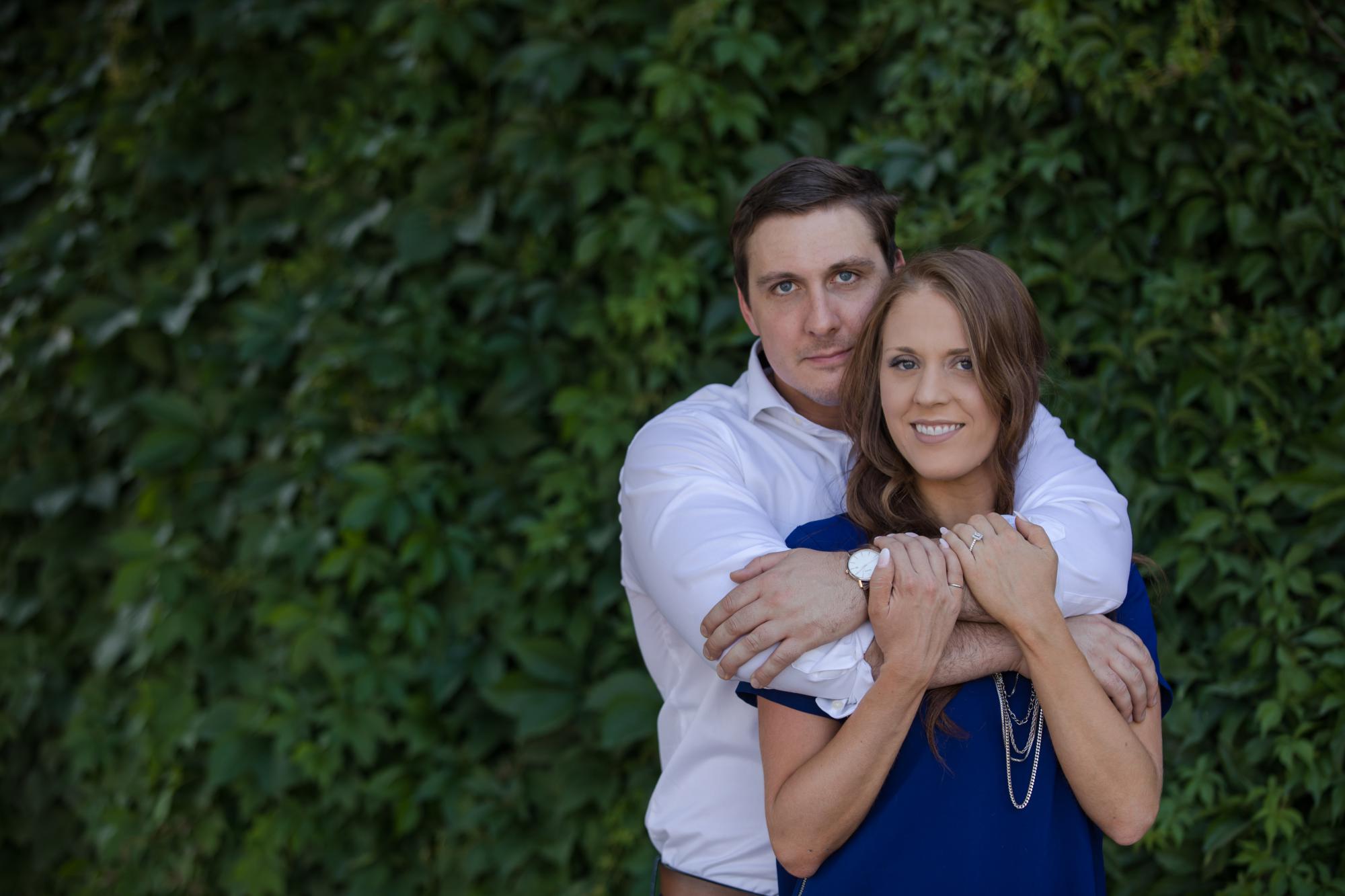Denver couple hold each other in front of green wall