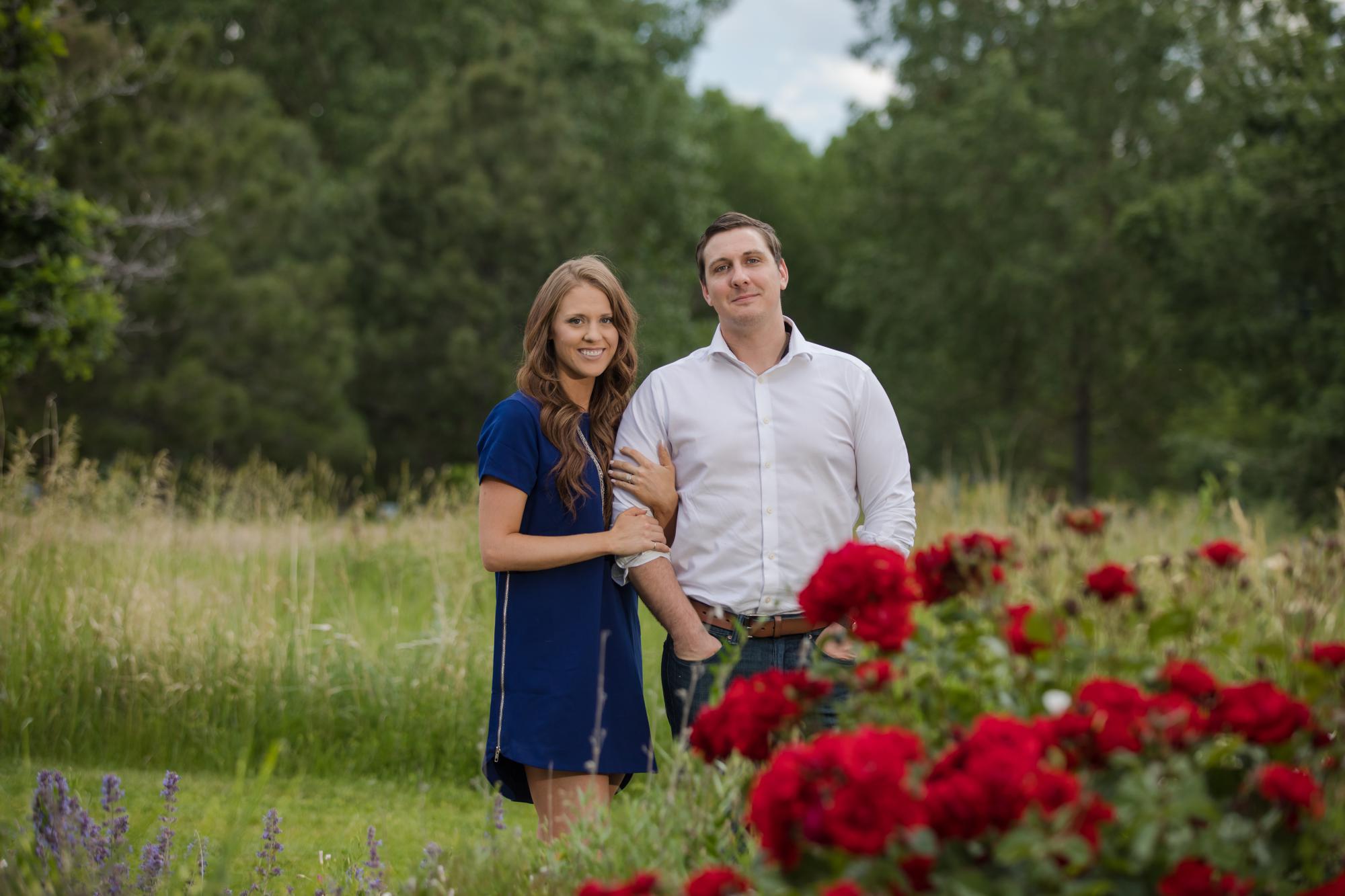 Denver couple pose in front of rosebush