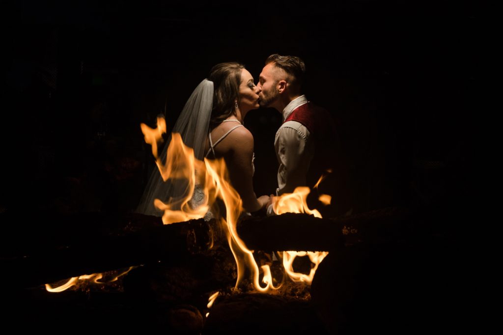 Colorado newlyweds kiss behind firepit