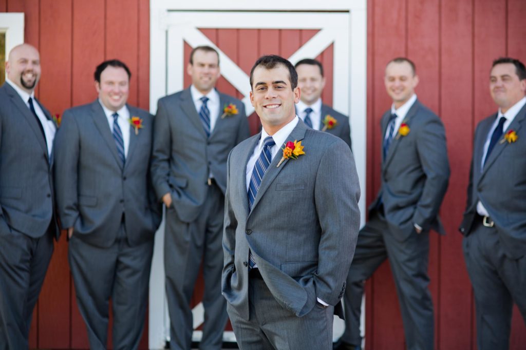 grooms with groomsmen in front of barn