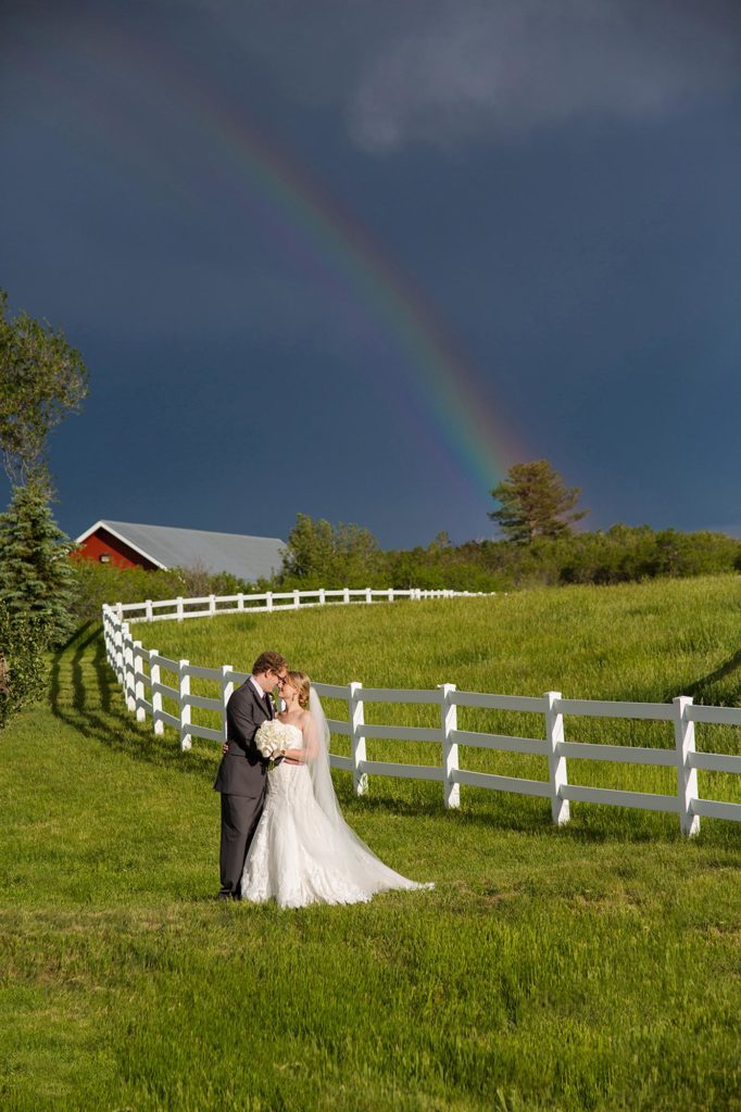 rainbow with bride and groom in field