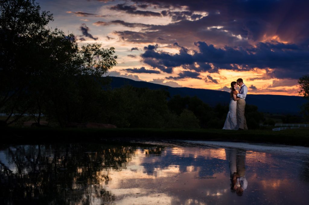 sunset with lake reflection of bride and groom