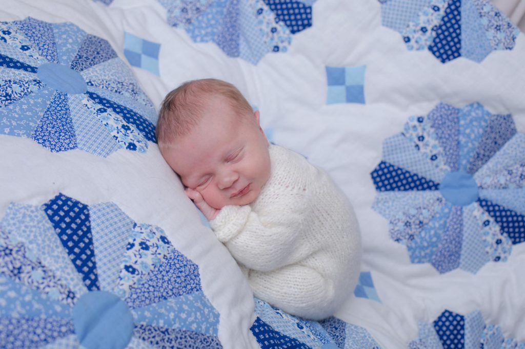baby on special quilt posed for home newborn photographer