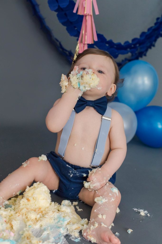 Baby boy stuffs his face at twins cake smash