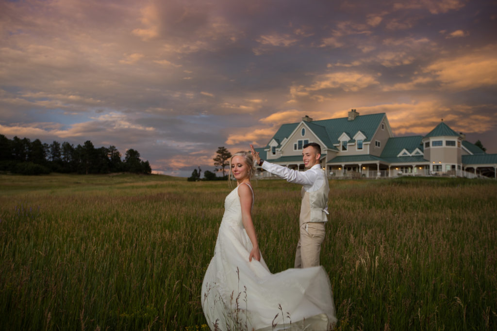Colorado newlywed couple poses in front of modern farmhouse wedding venue
